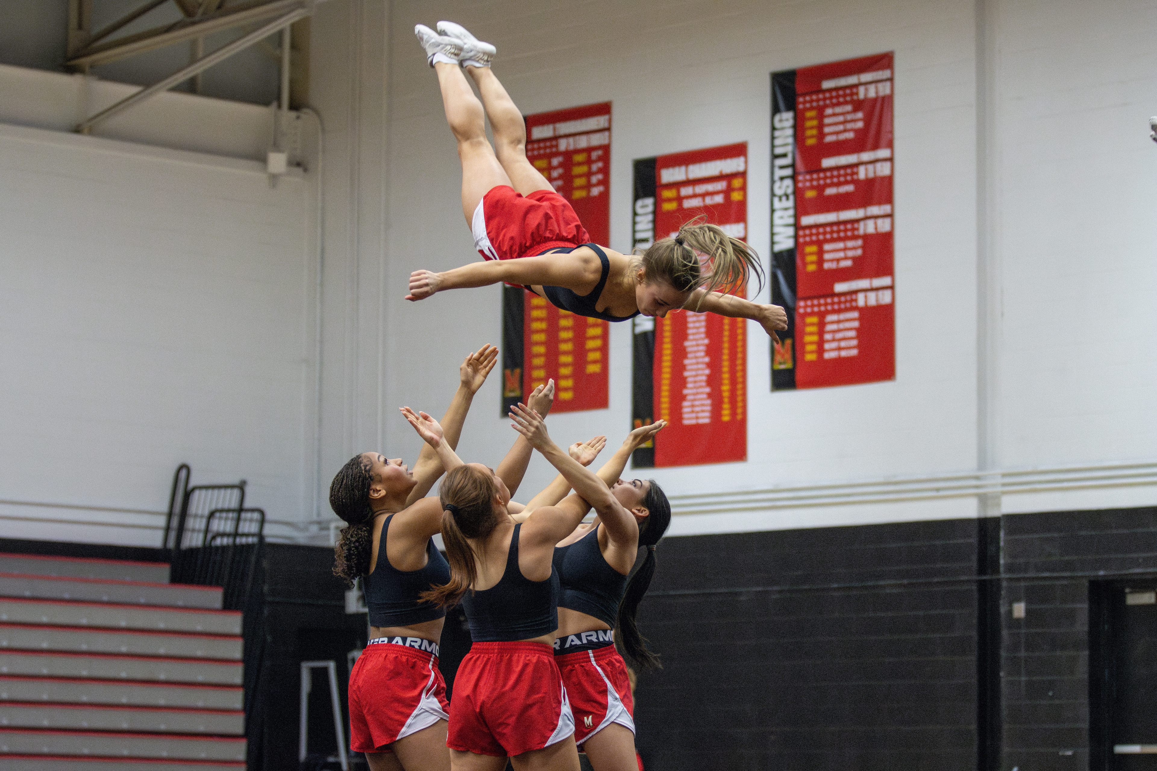 Natasha Slutzky, Kaelin Hibbs, Elizabeth Cornwell and Victoria Edozien practice a dismount at Maryland cheer’s practice on Feb. 27, 2025.