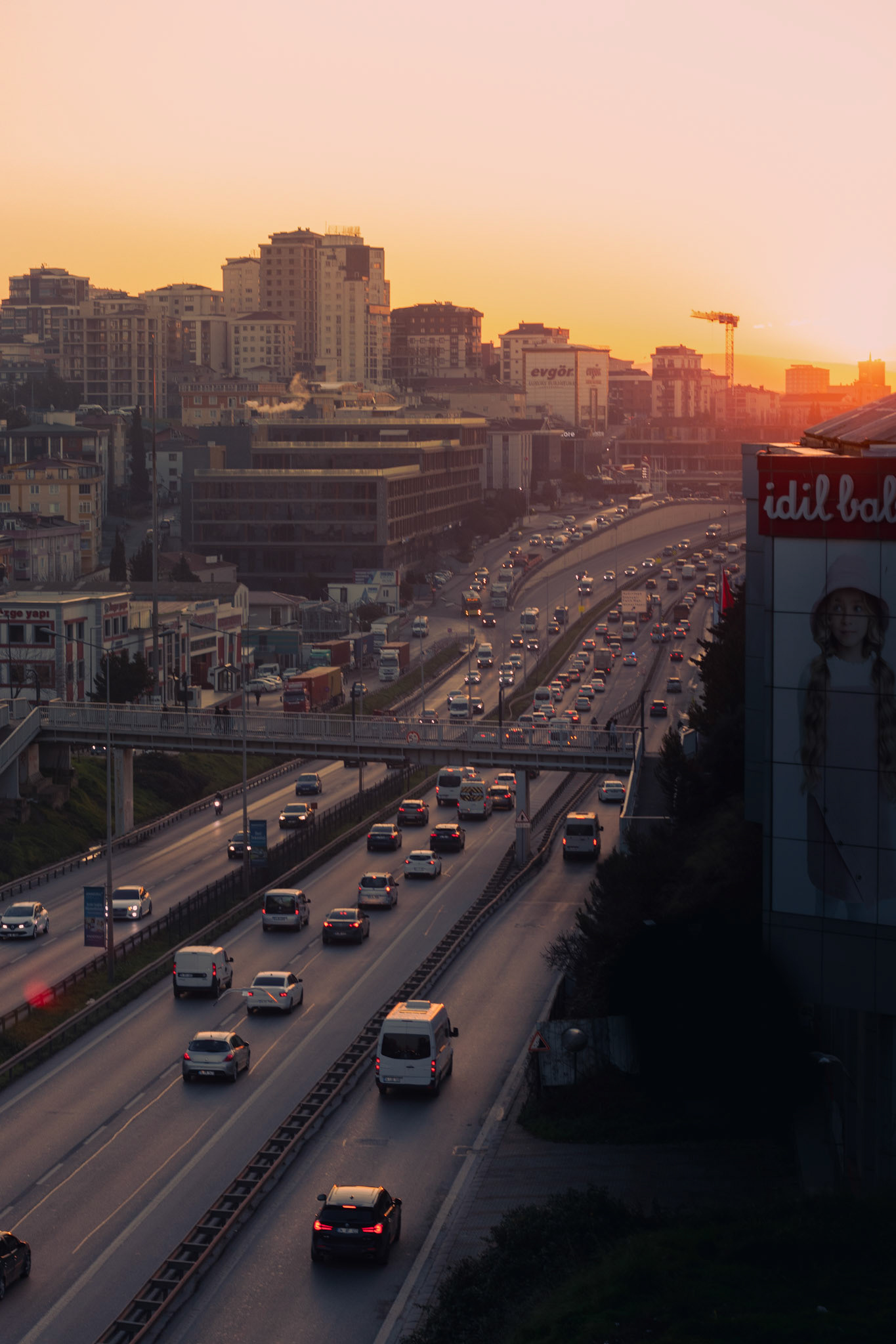 İstanbul'da bir sabah vakti... Gün doğumunun ilk ışıklarının şehre süzülüşü, işe giden insanların telaşıyla harmanlanıyor. Trafikte bir karmaşa, bir koşuşturma var. Herkes yeni güne başlamak için yola çıkmış. Bu fotoğraf, şehrin hiç durmayan nabzını ve her yeni güne umutla başlayan insanların enerjisini yansıtıyor.