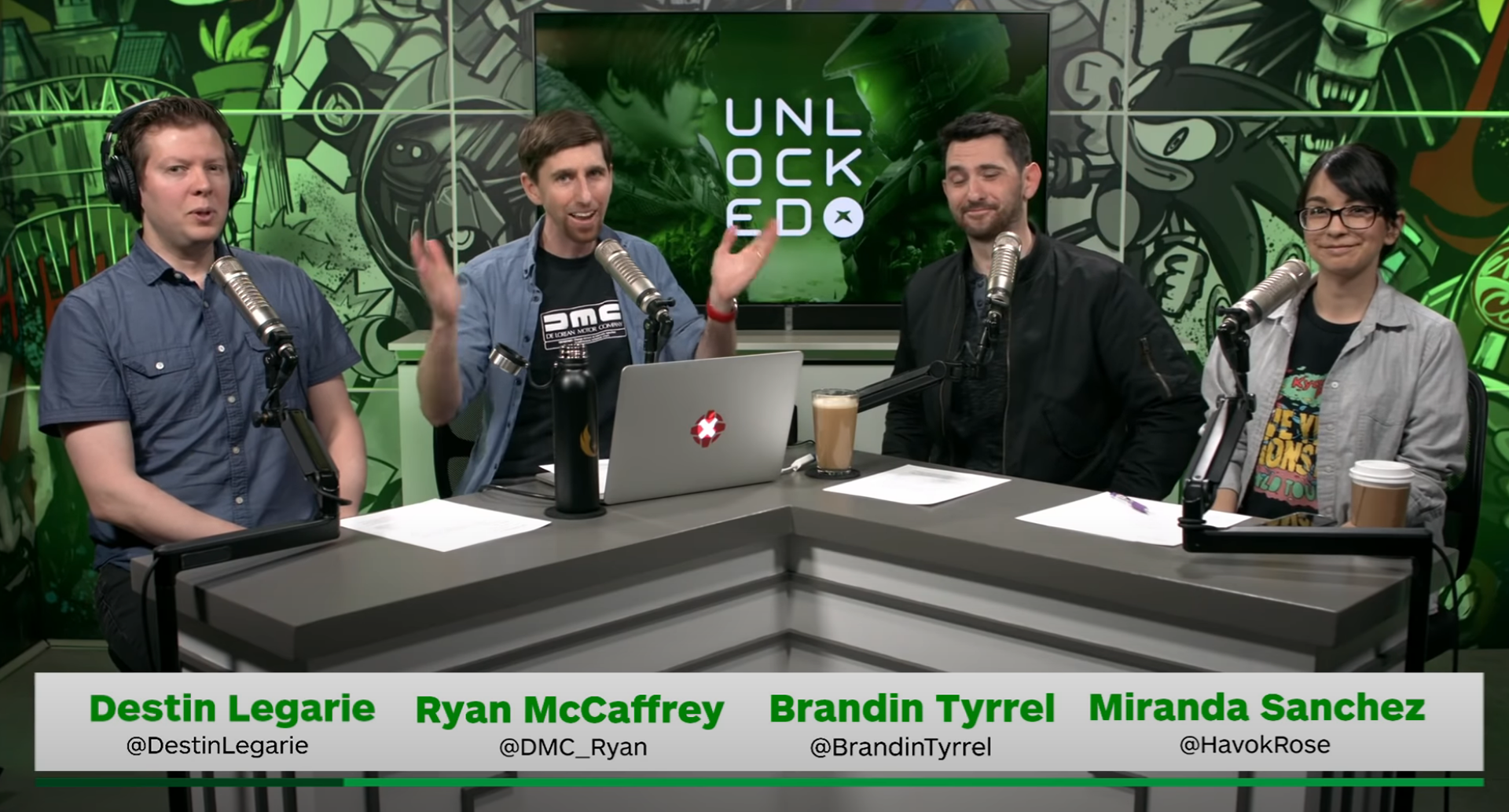 Screenshot of the IGN Podcast Unlocked where my graphic was used as the wallpaper on the TV behind the cast.