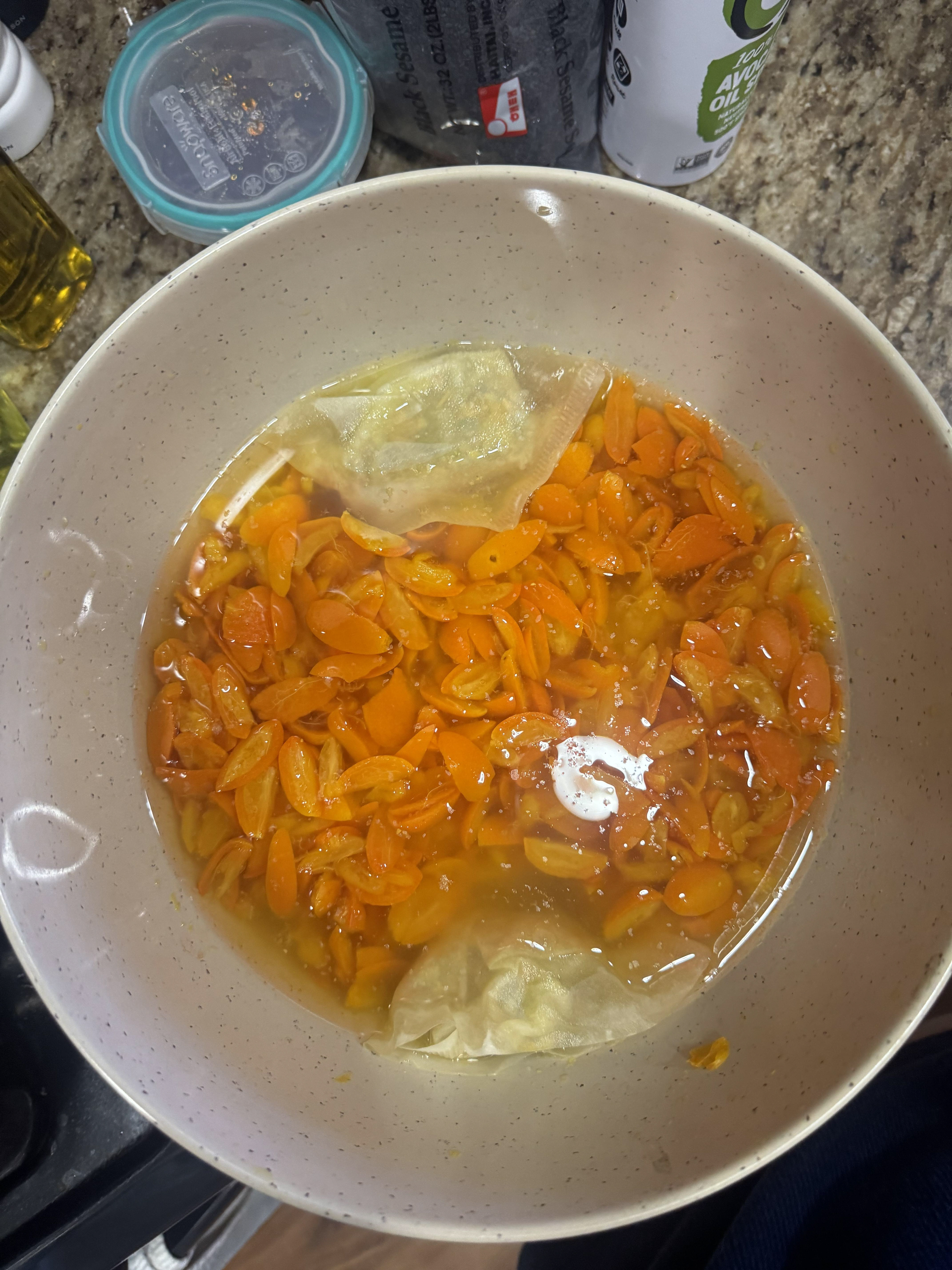 Kumquats sliced and soaking with their seeds.