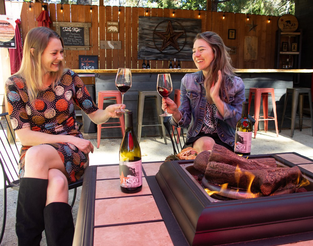 Two people enjoying wine by fireplace