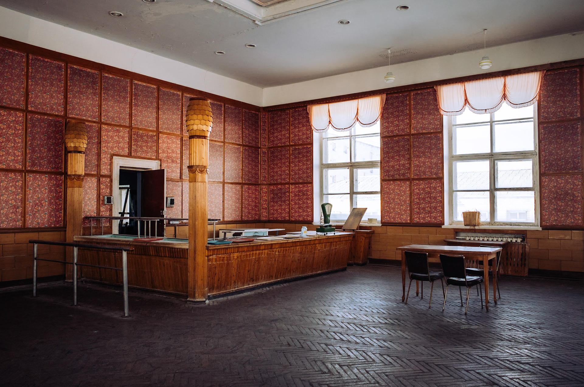 Der alte Tresenbereich der Kantine steht noch mit seinen hölzernen Säulen und der Waage, die früher für die Essensausgabe genutzt wurde. Der Raum ist gut erhalten, aber die Zeit hat Spuren an der Einrichtung hinterlassen.