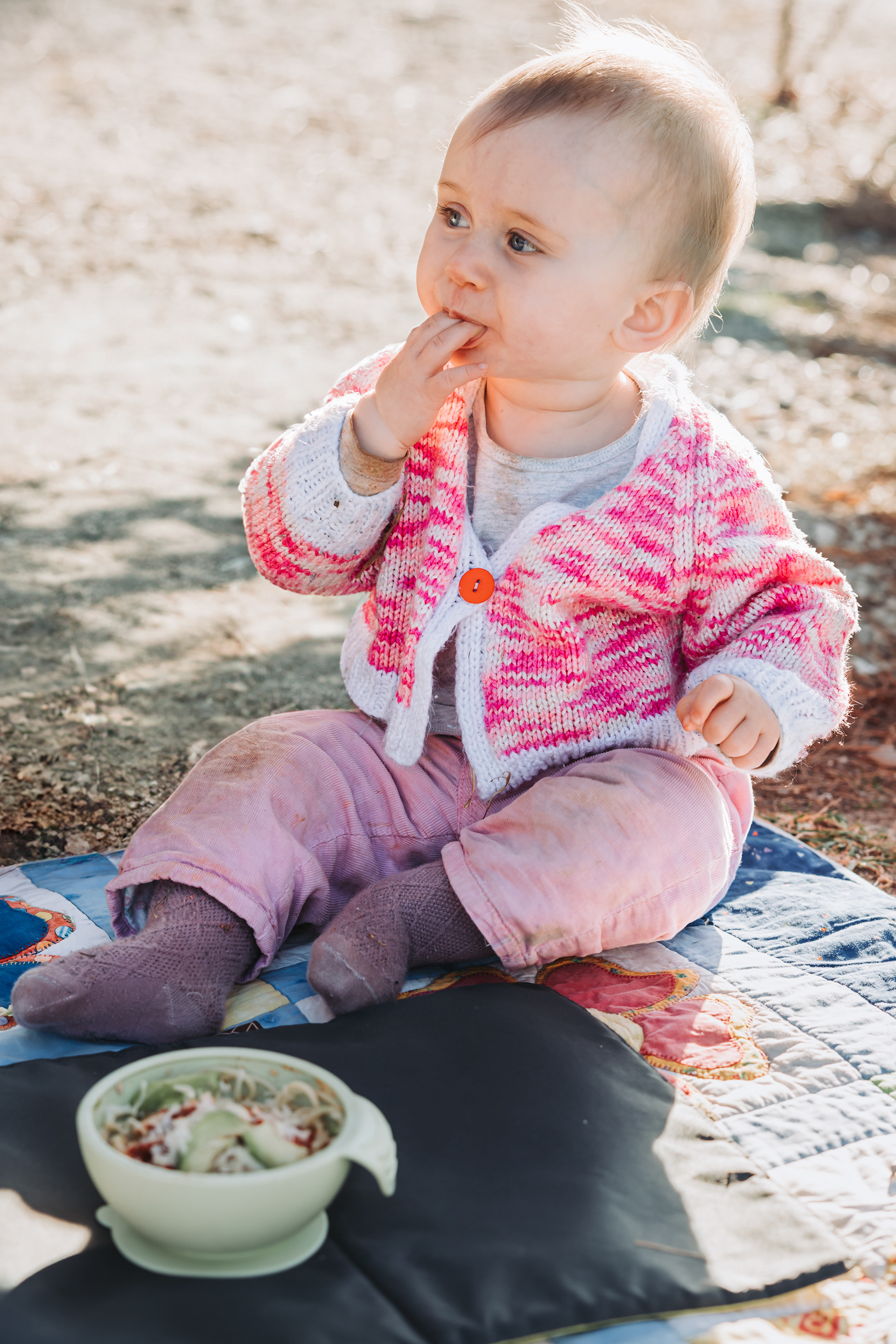 Baby Emma nibbles her fingers at Lake Wanaka