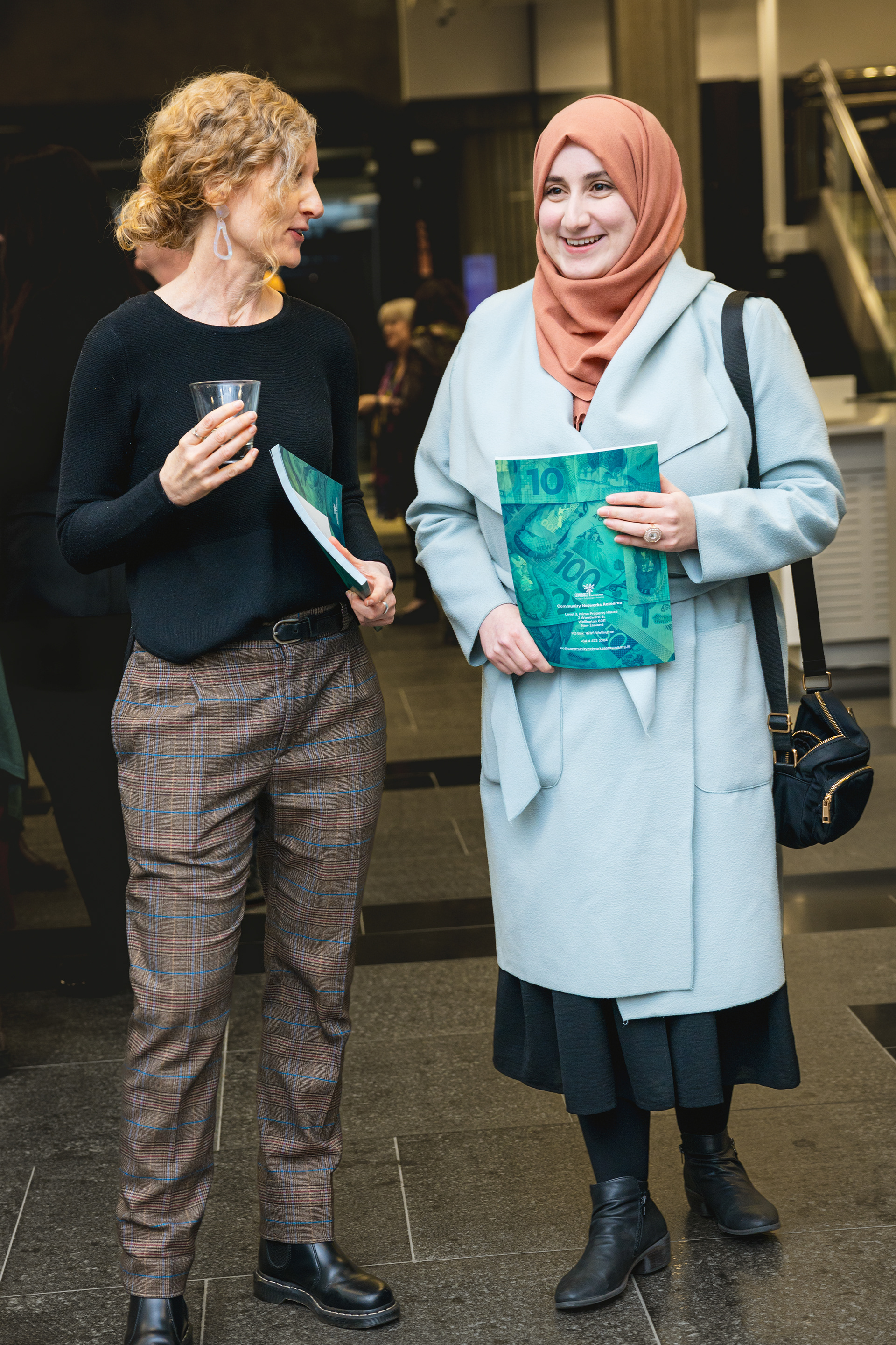 Attendees hold Better Banking booklets and chat during the launch