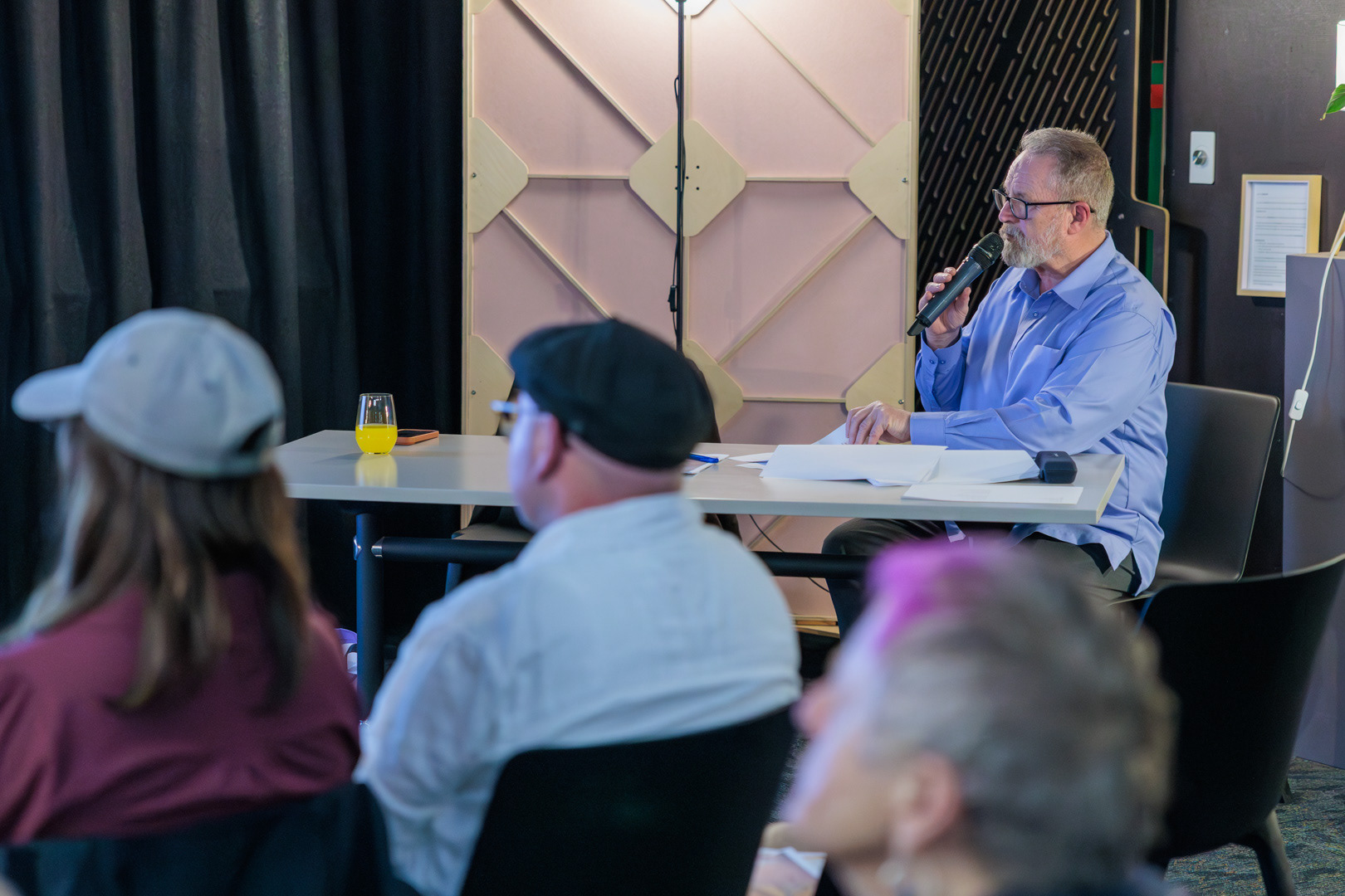 Richard Benge speaks into a microphone at the Arts Access Aotearoa AGM 2026