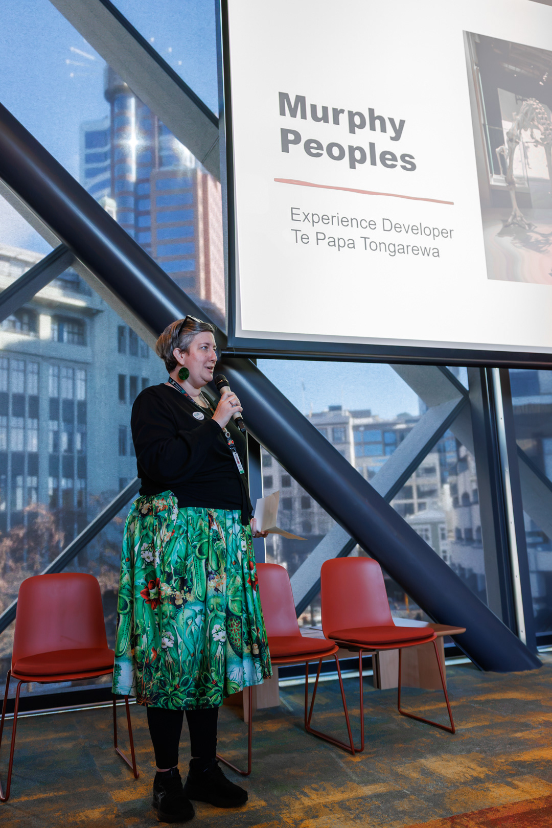 Murphy People's speaks into a microphone while presenting at the hui.