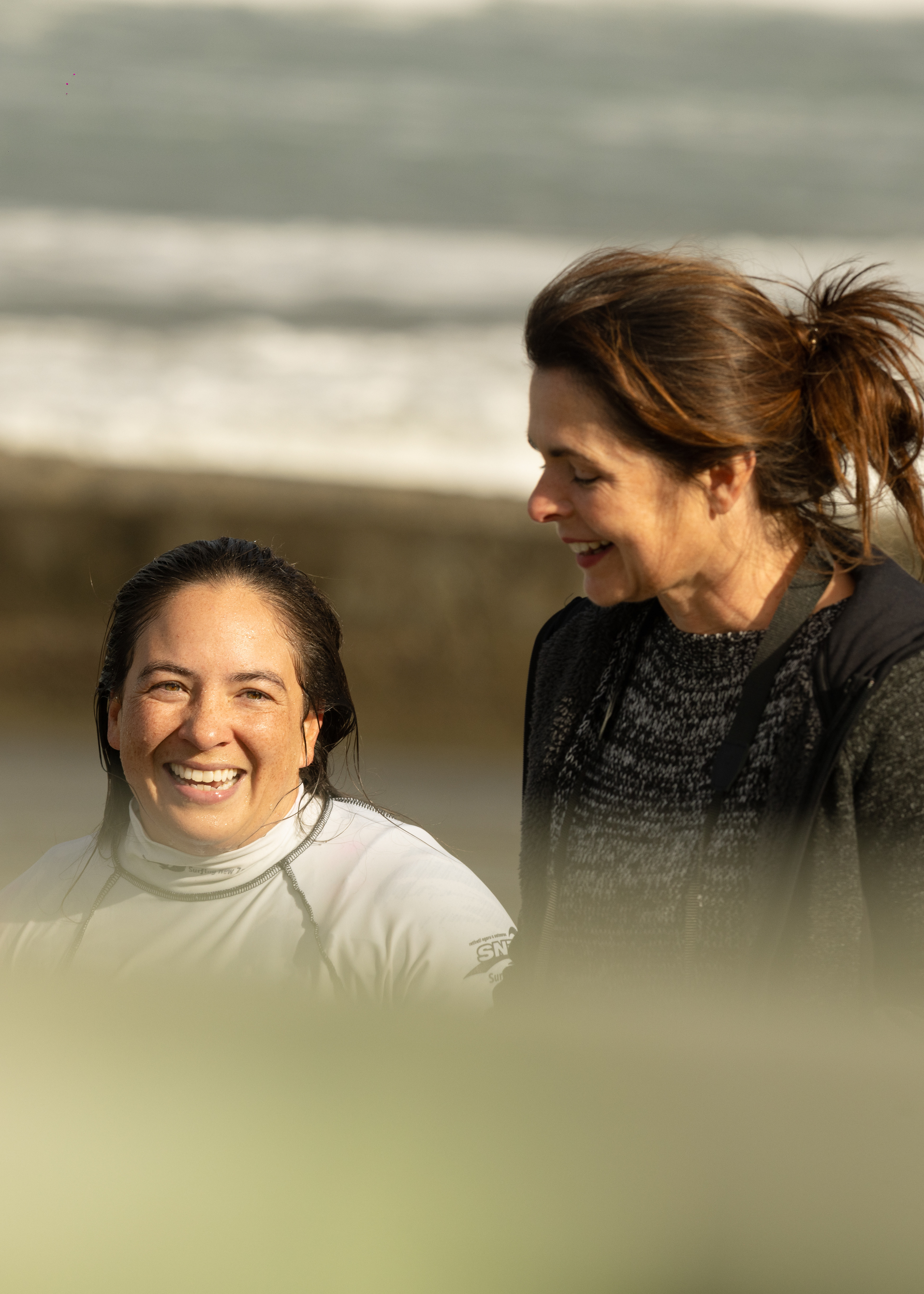 A competitor is met at the waters edge by a friend after her heat.