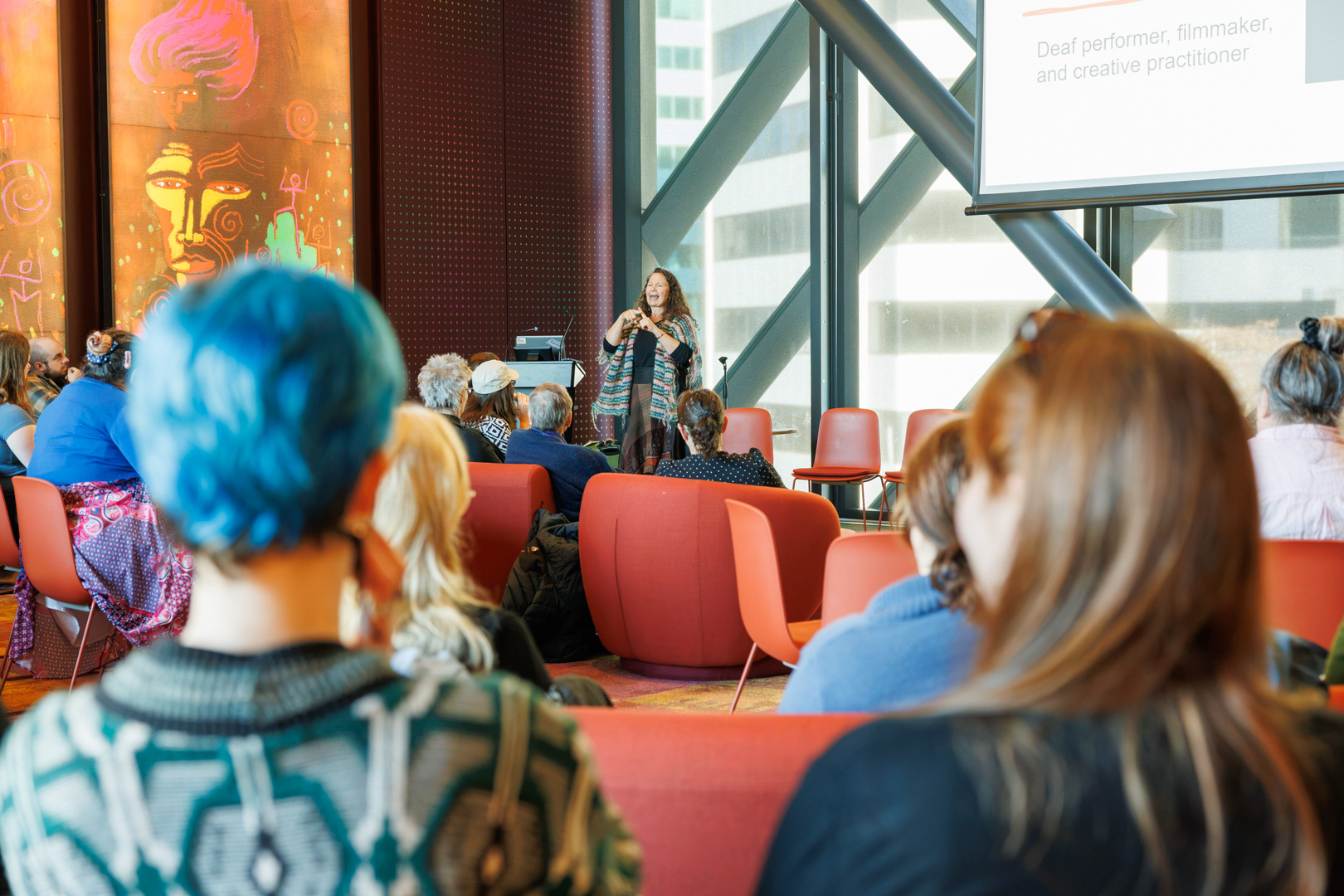 Deaf performer and artists, Polly Ferguson, communicates using NZSL while presenting to the hui attendees.