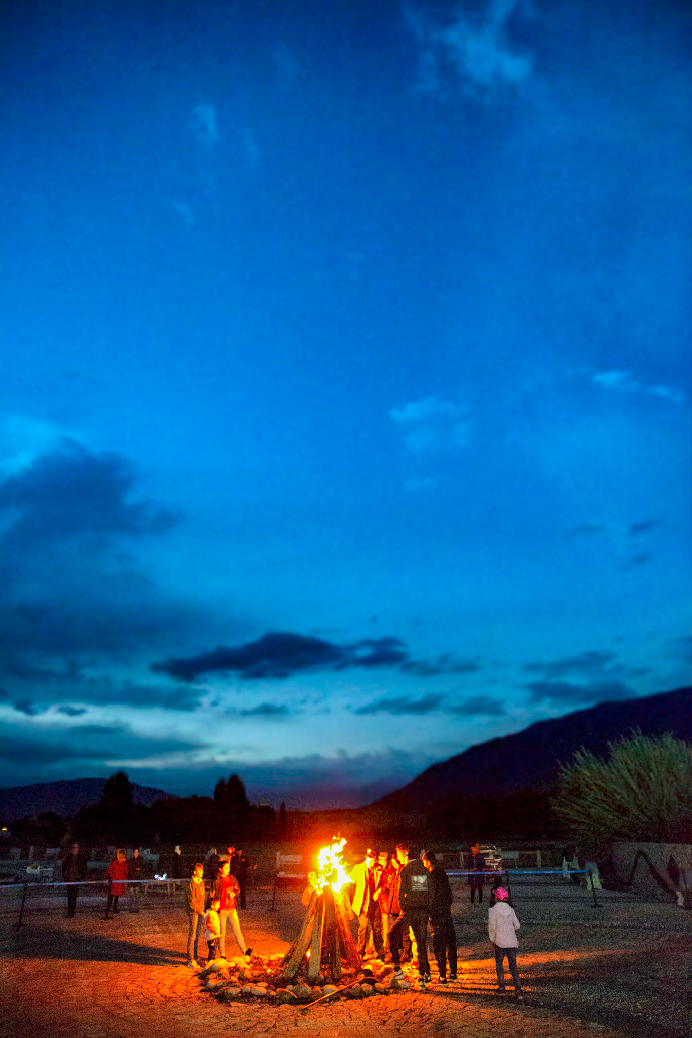 tashgurkan, China - September 6, 2018 :group of people standing around a campfire