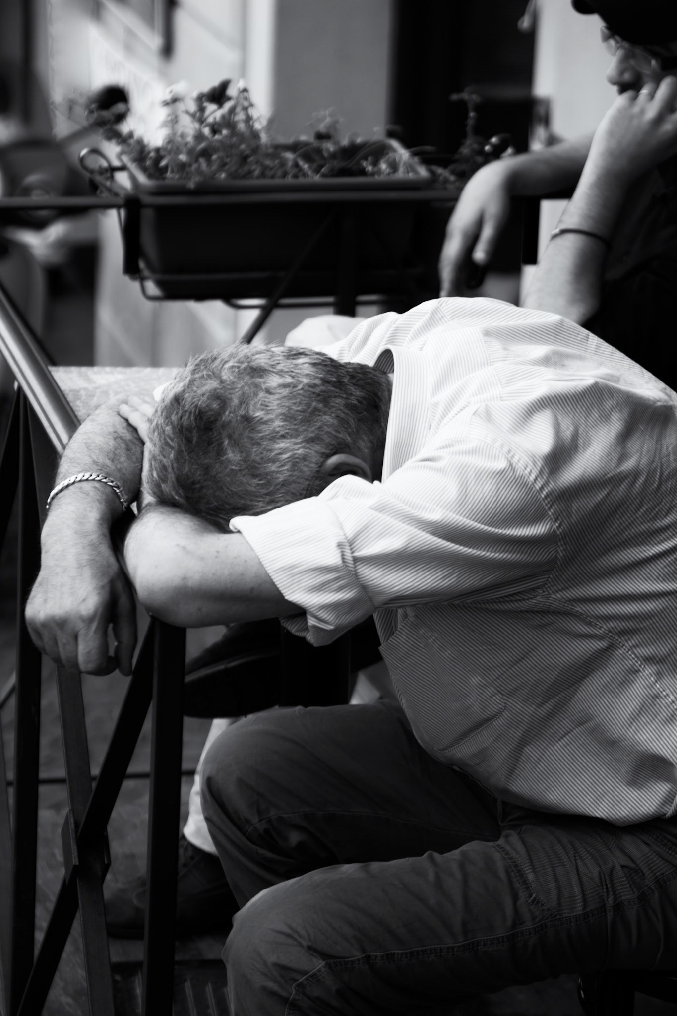 Gubbio, Italy - july 14, 2011 : man resting his had on his arms in a small outdoor cafe on the streets of Gubbio.