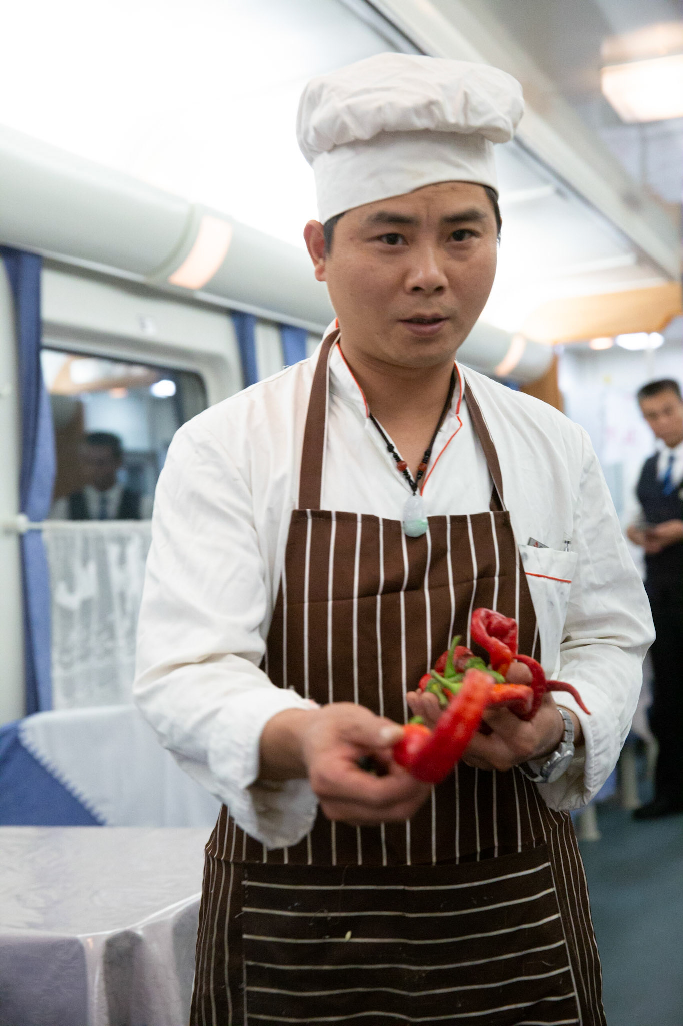 Urumqi, China - september 4, 2018 : Cook holding pepper in the restaurant carriage of the Urumqi - Kashgar train, 2018 : Cook holding pepper in the restaurant carriage of the Urumqi - Kashgar train