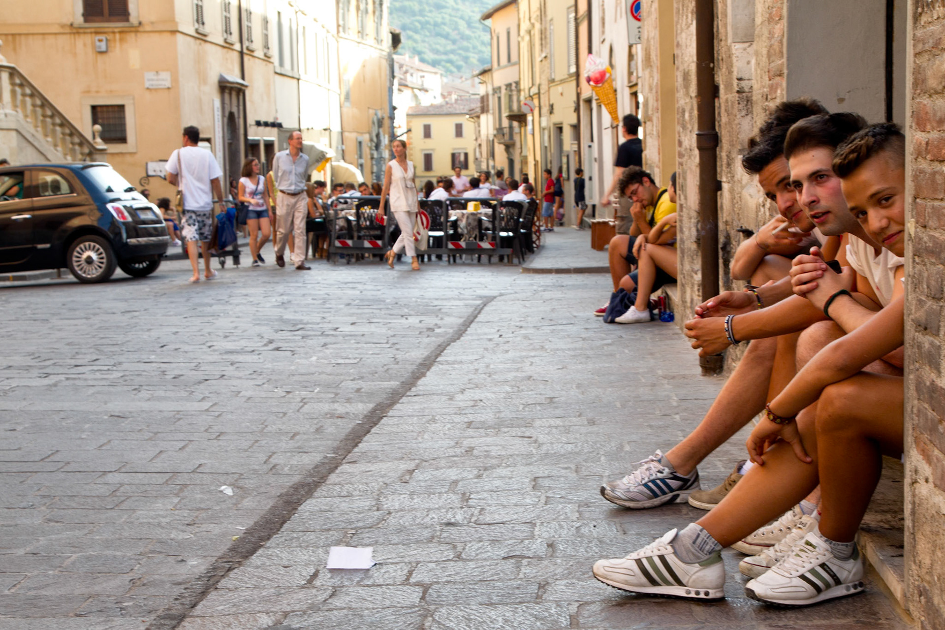Gubbio, Italy - at 18:00 sharp the road gets blocked for traffic, Ice salon 'la Meridiana' puts tables and chairs on the road, youth hangs out and buys icecream, and Italian young men, spend their early evenings watching young women, who pretend not to notice them.