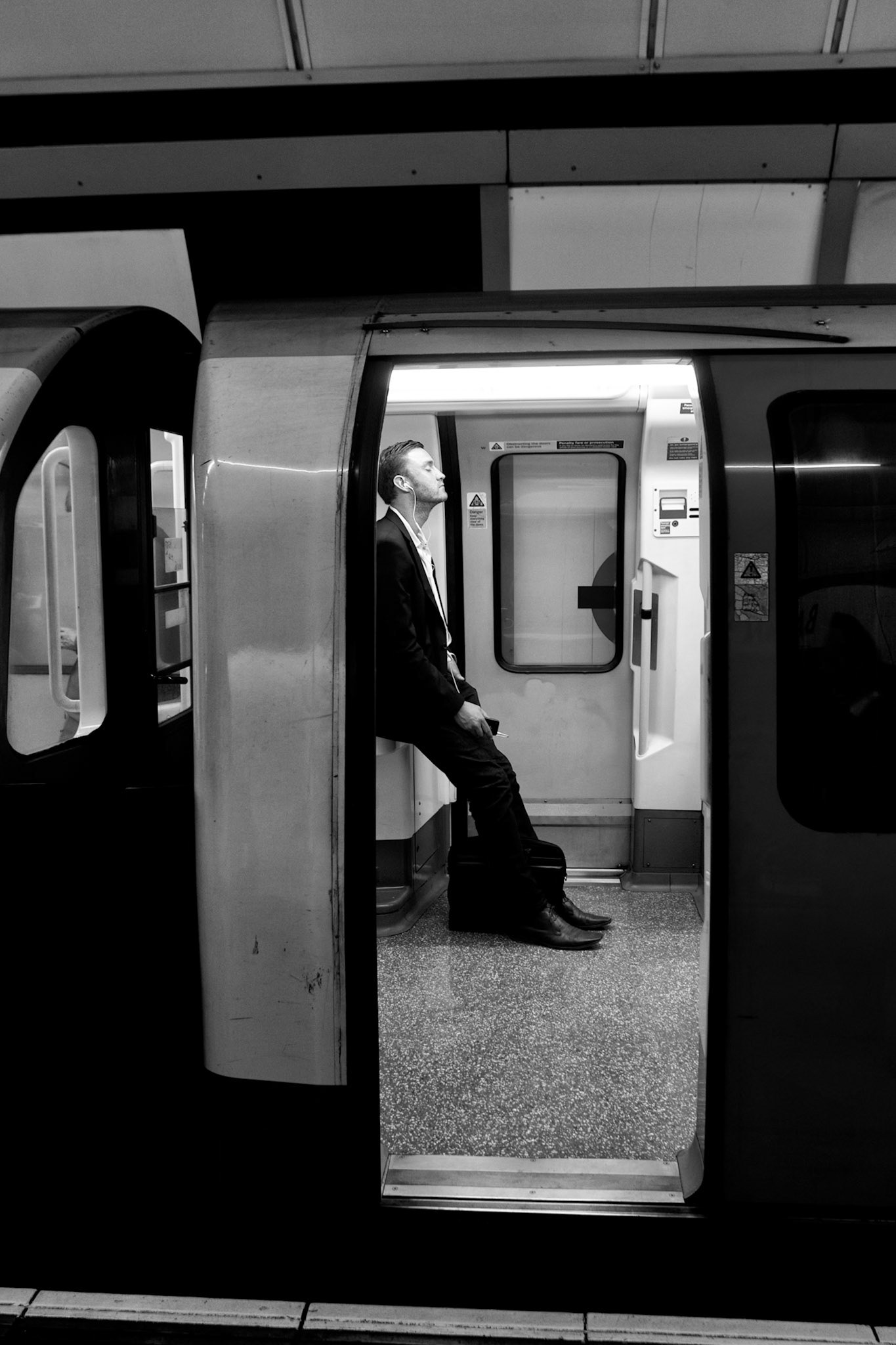 London, United Kingdom - may 4, 2011: Man standing in a london underground train carriage, his eyes closed, earphones in and leaning backwards