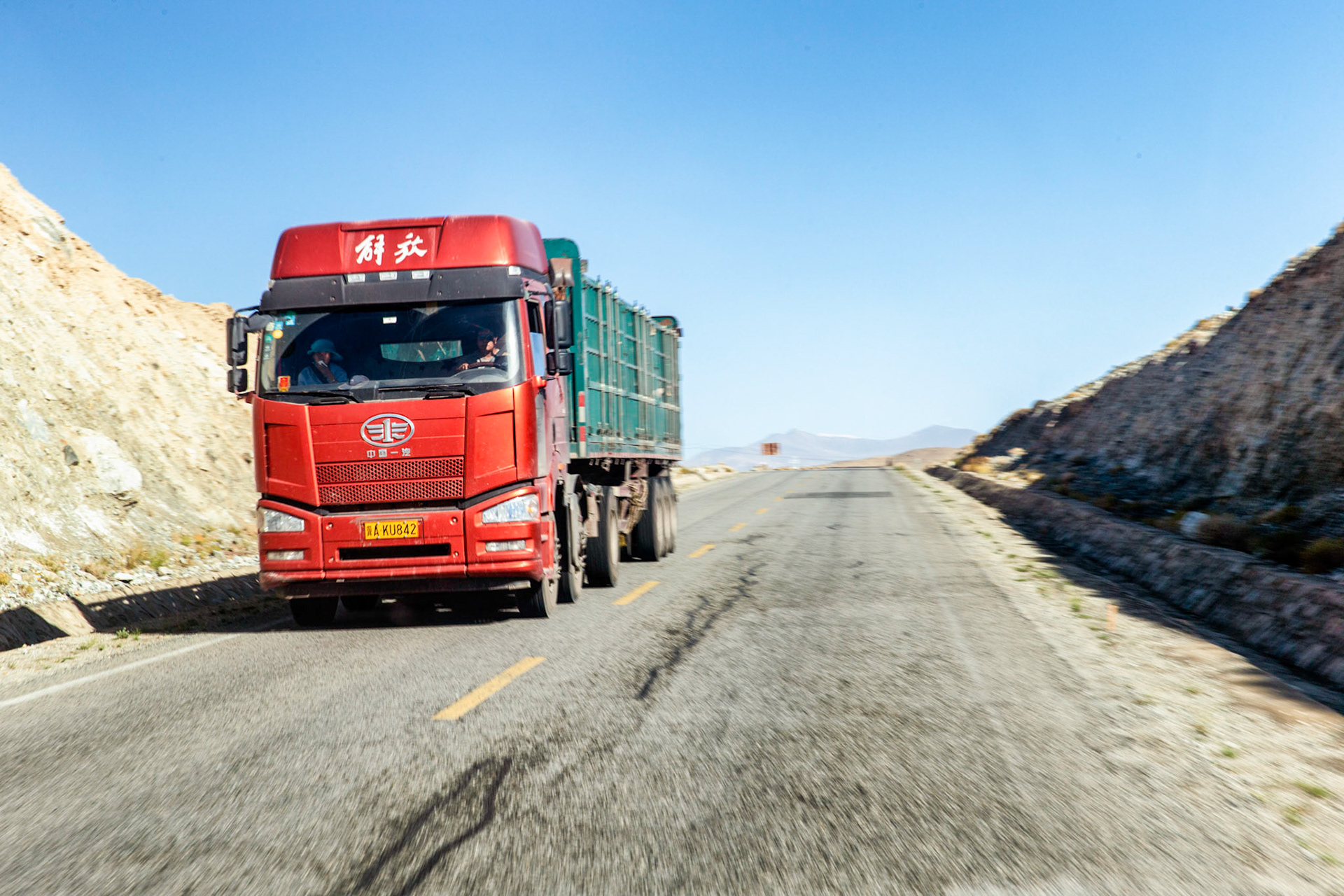 Karakoram highway, China - September 8th, 2018 : The Karakoram highway is the main route from China to Pakistan, from Kashgar, via Tasgurkan to Pakistan. The iconic red truck is the staple chinese transport vehicle, visible everywhere.