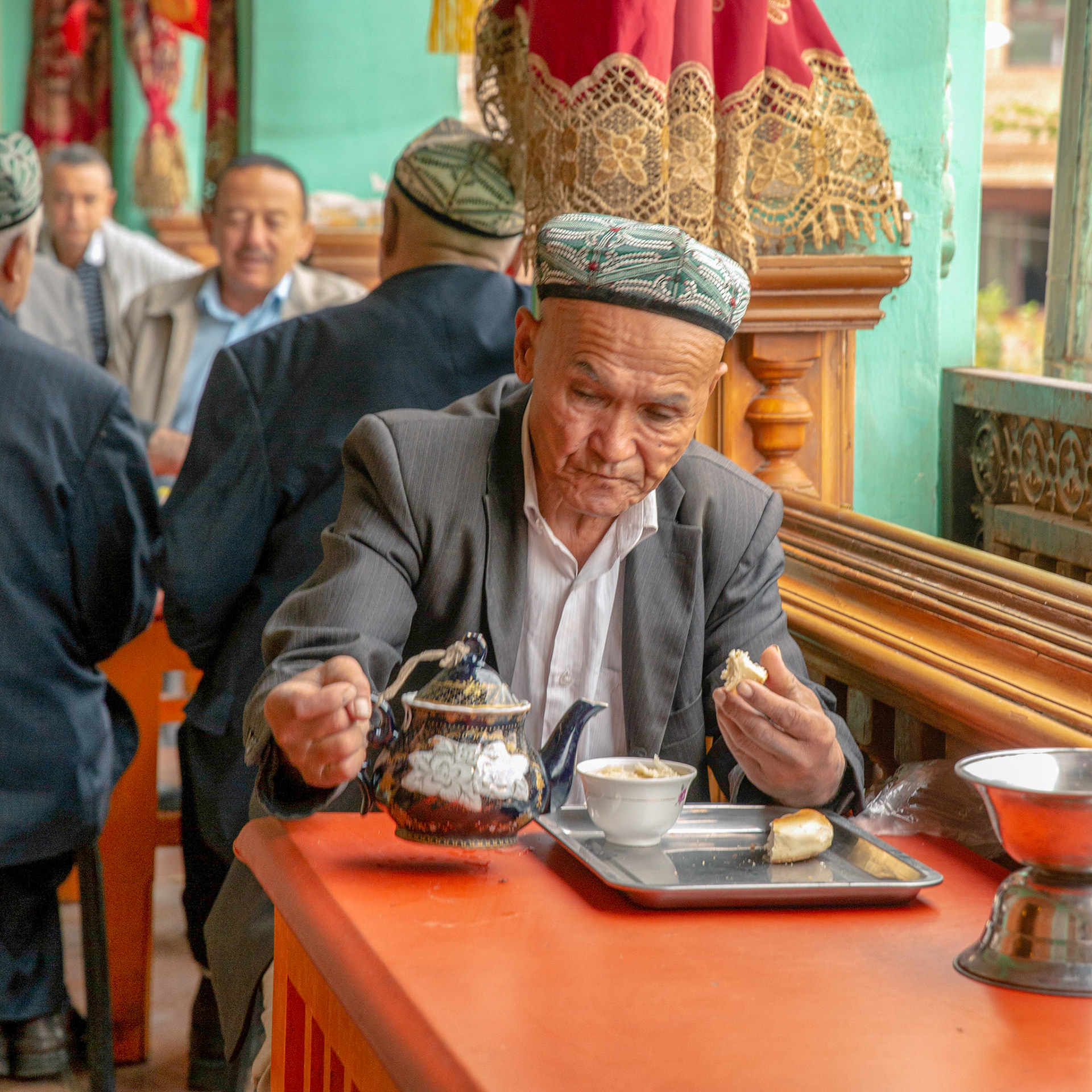 Kashgar, Xinjiang, China - September 5, 2018: Old man drinking tea in a traditional old tea house in Kashgar