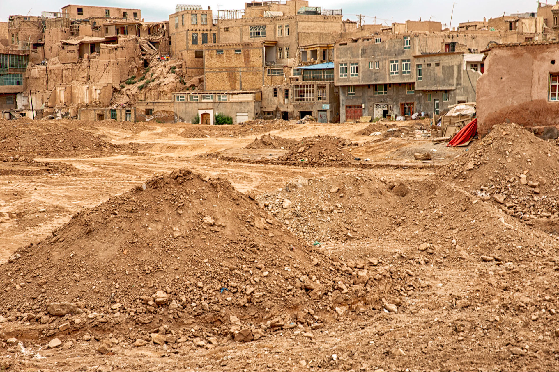 Kashgar, Xinjiang, China - September 5, 2018: Piles of rubble in front of the partially demolished houses of the old city in Kashgar, Xinjiang.