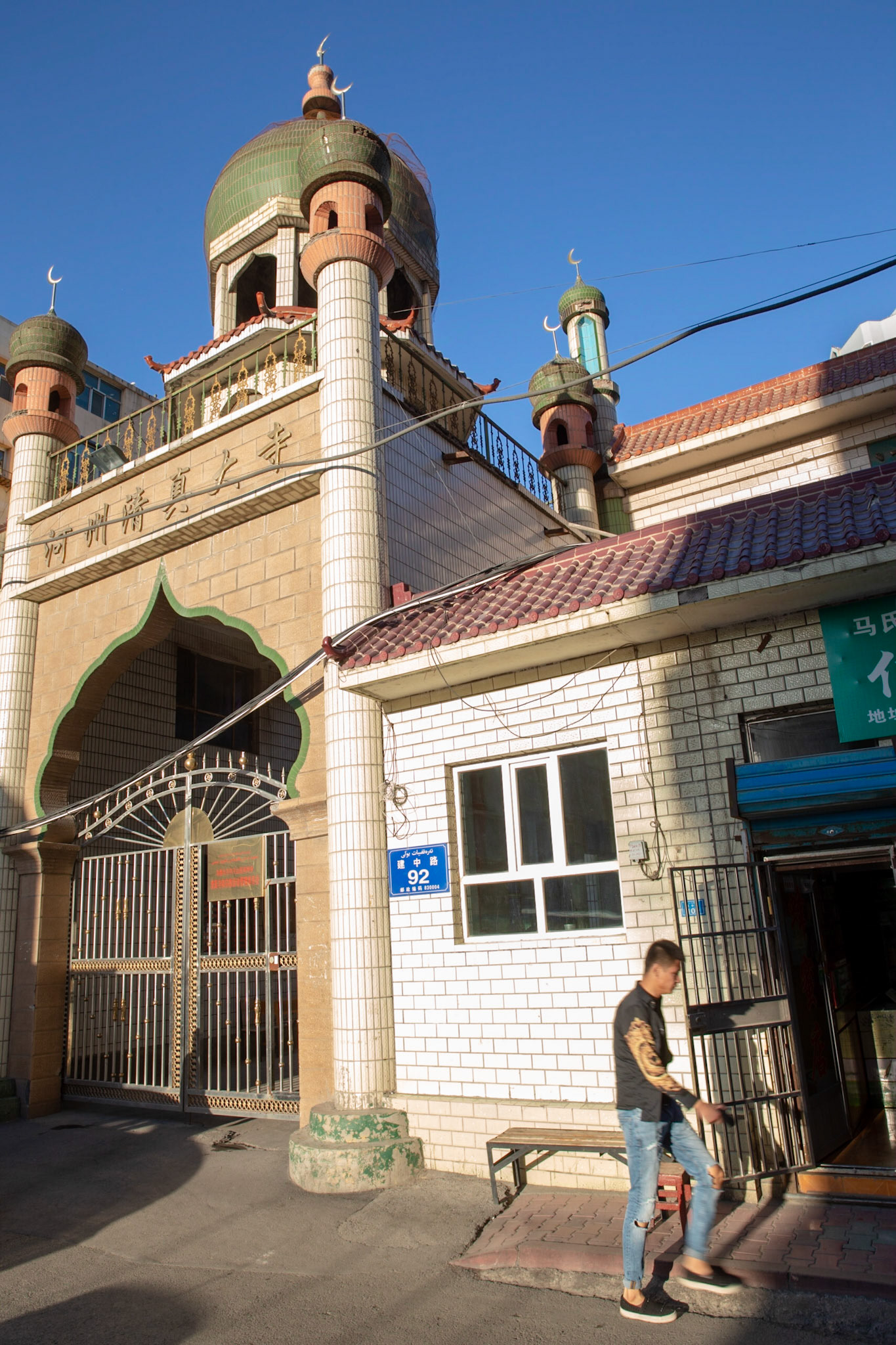 Urumqi, China - september 1, 2018 :  Man walking in front of a mosque in Urumqi, built in Muslim architecture, but with Chinese characters saying "Muslim temple."