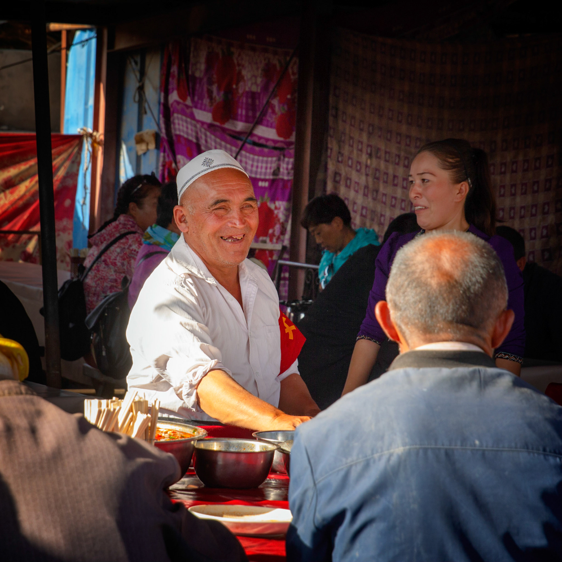 Kashgar,  China - September 9th, 2018 : Cooking smiling to guests in a Kashgar food tent.