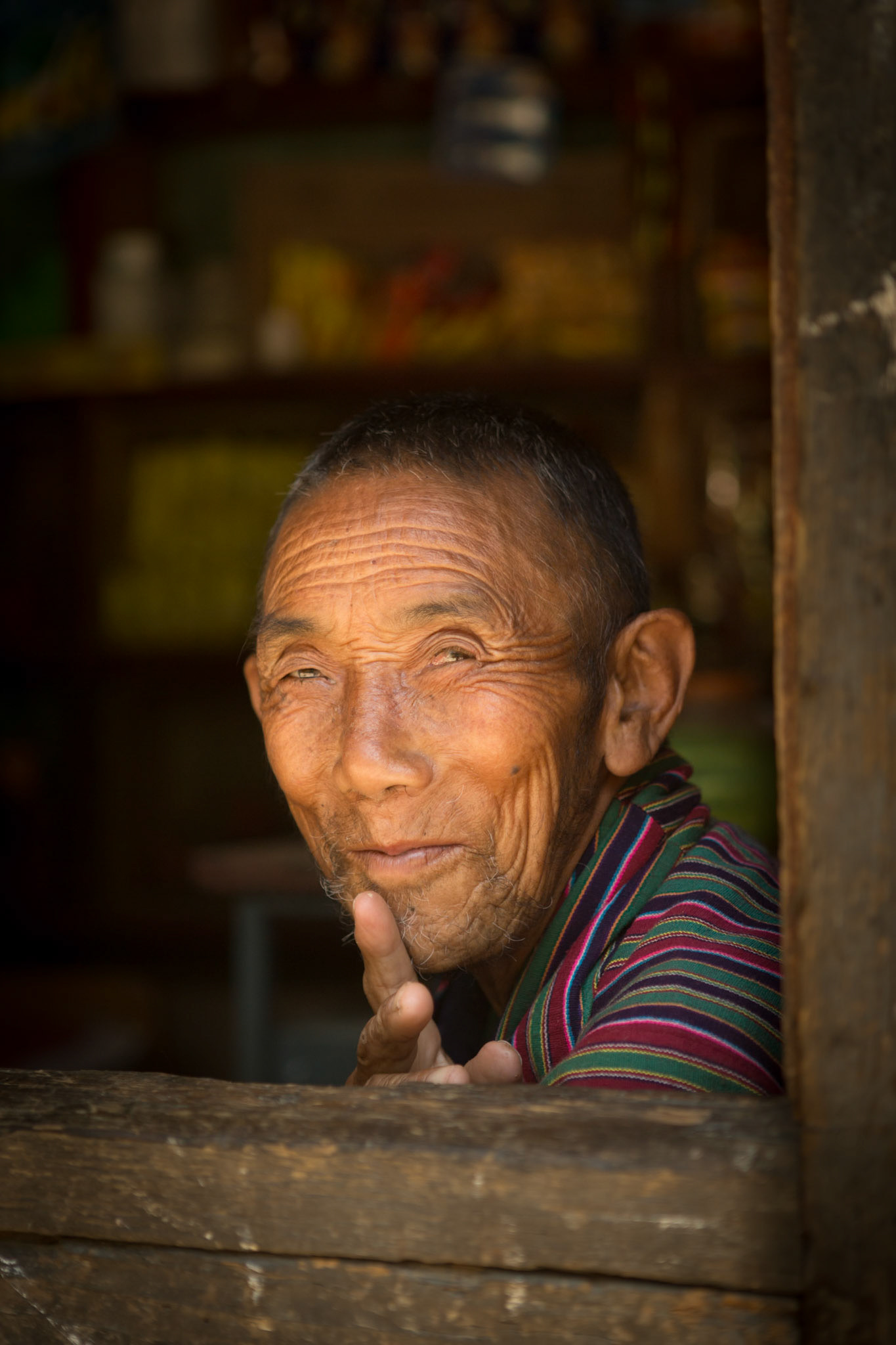 Thimpu, Bhutan - September 278th, 2012 :  old man looking out of a shop window in Thimpu.