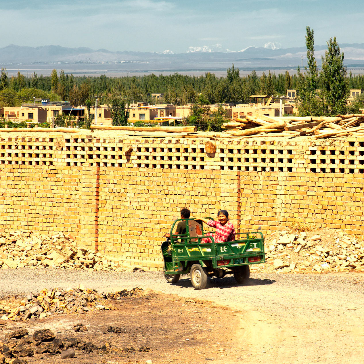 Turpan, Xinjian, China - september 2, 2018 : Farmers driving their 3-wheeled vehicle on the sun drenched slopes near Turpan.