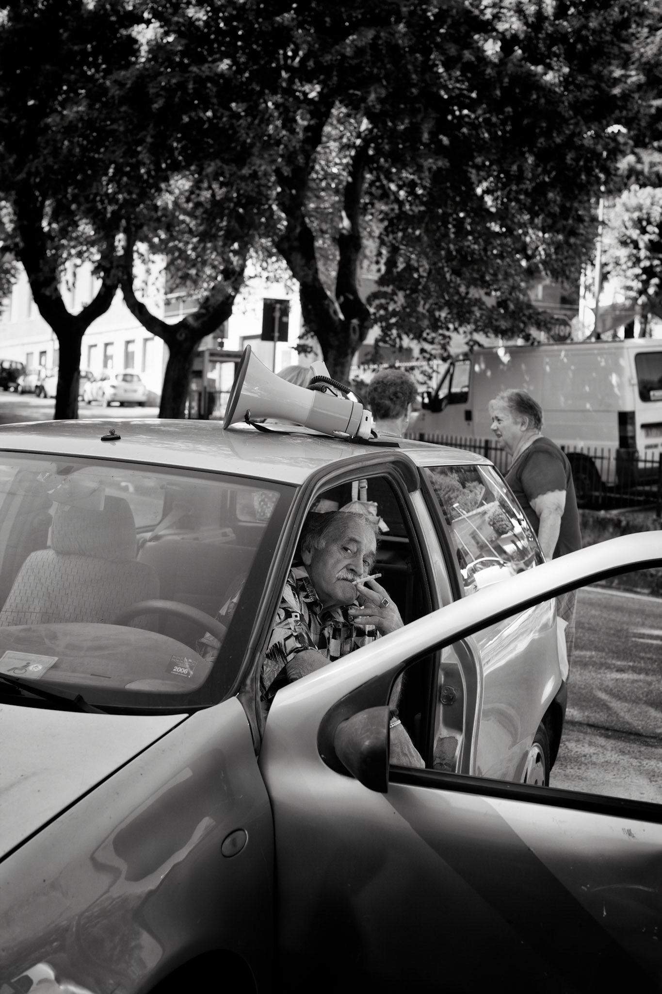 Cagli, italy - August 1st 2012 :  man relaxing in the front seat of his car, door open, smoking a cigarette. [url=http://www.istockphoto.com/search/lightbox/11293042#64eec1d][img]http://www.piebinga.nl/banners/italy.jpg[/img][/url]