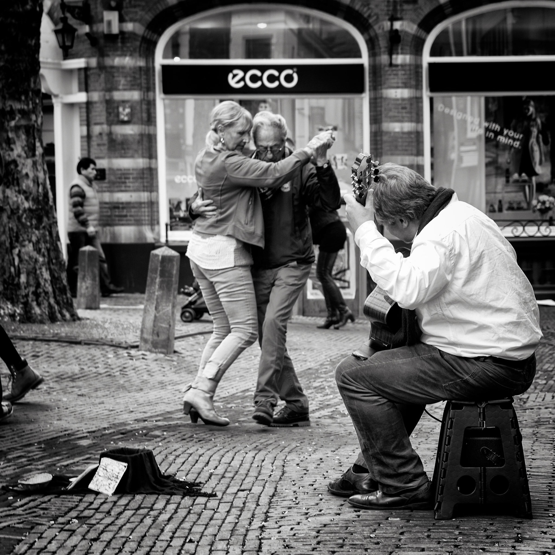 Anne-wil and Jan-Pieter are dance partners, they just happened to walk in the street where Christiaan is playing a tango. Anne-wil "If you hear this music, you just have to dance". Jan-Pieter "If this music does not  touch your heart, you are made of concrete".