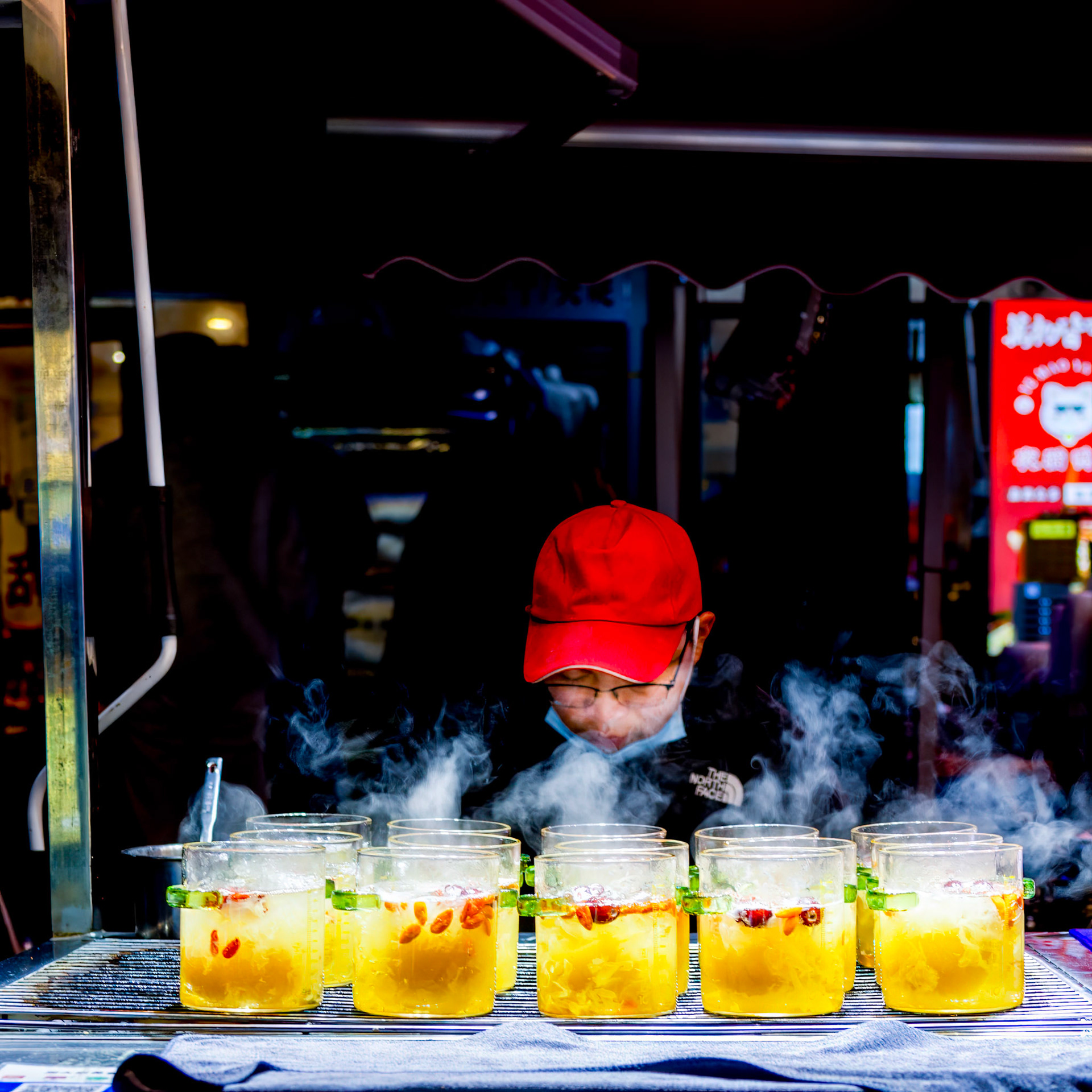 Changsha, China - 25 Feb 2024: Stall with baked pear and sugar, steaming in the winter night. 冰糖烤梨