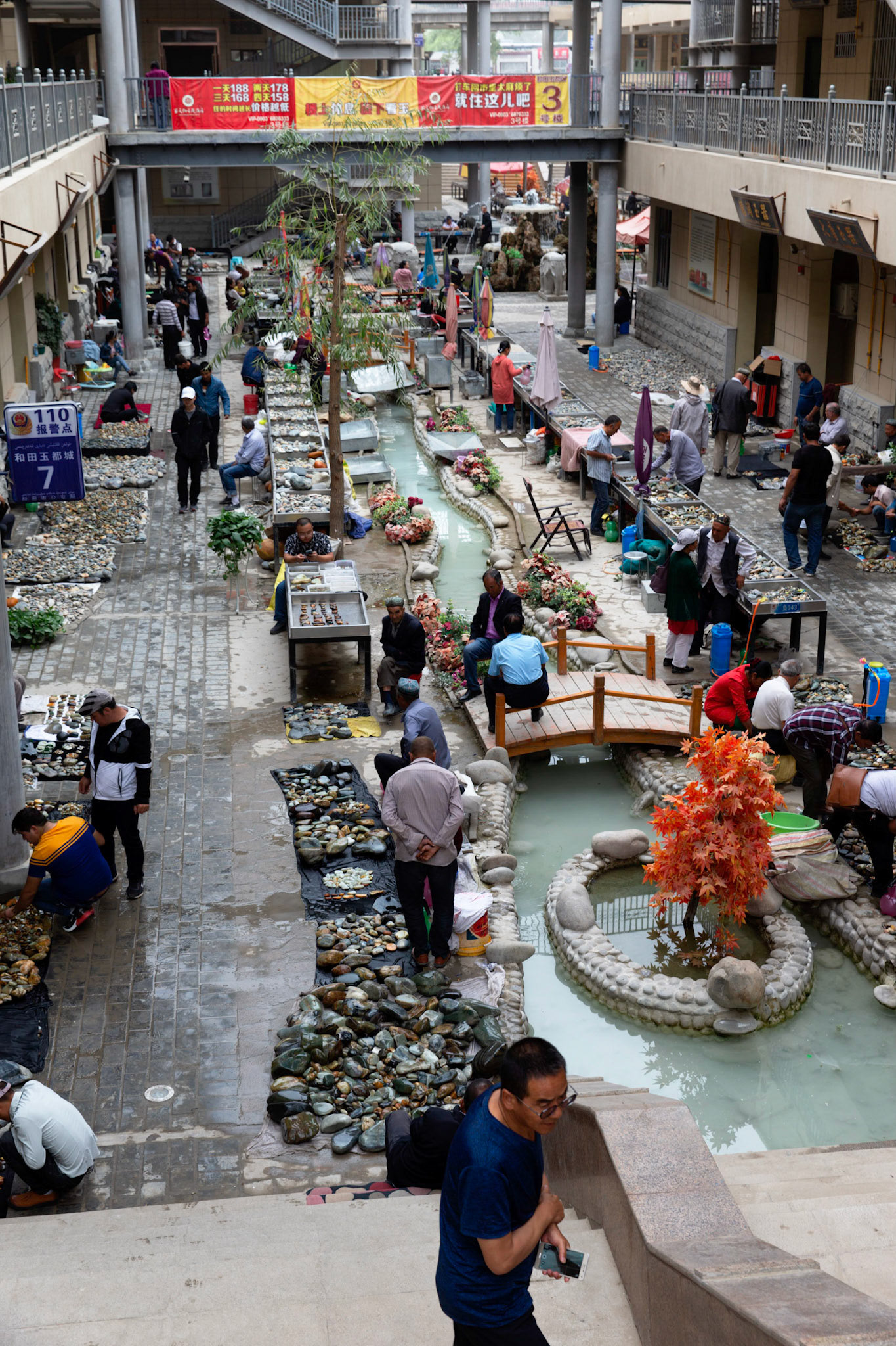 Hotan, China - September 13th 2018 :  Hotan is traditionally a place where Jade is found and sold, many locals still look for interesting stones in the river and sell them here at the Hotan Jade market. Seller keep the stones wet to make them more attractive.