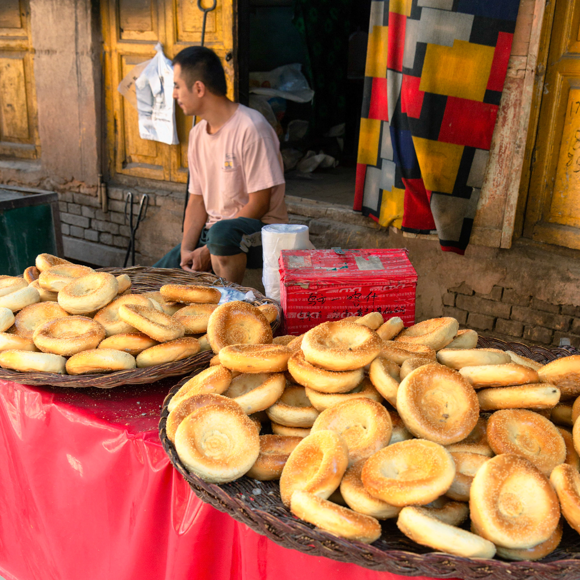 Kashgar,  China - September 10th, 2018 : Man weselling small nan breads at a street bakery in Kashgar
