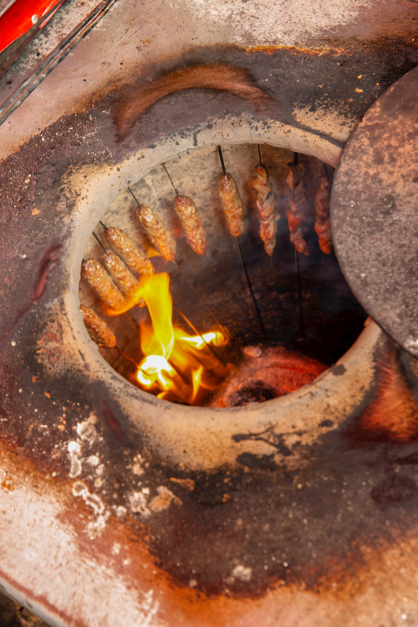 Sticks of lamb meat grilling above a fire at the Kashgar grand bazaar.
