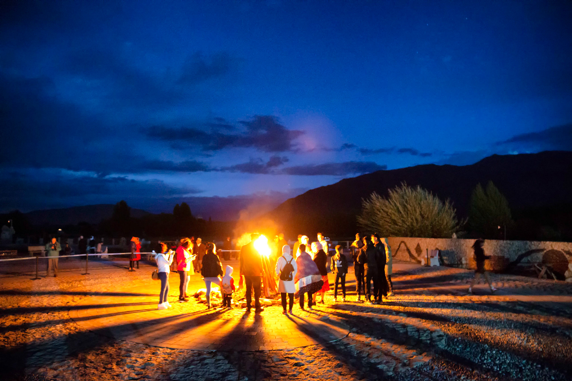Tashgurkan, China - September 6, 2018 :group of people standing around a campfire