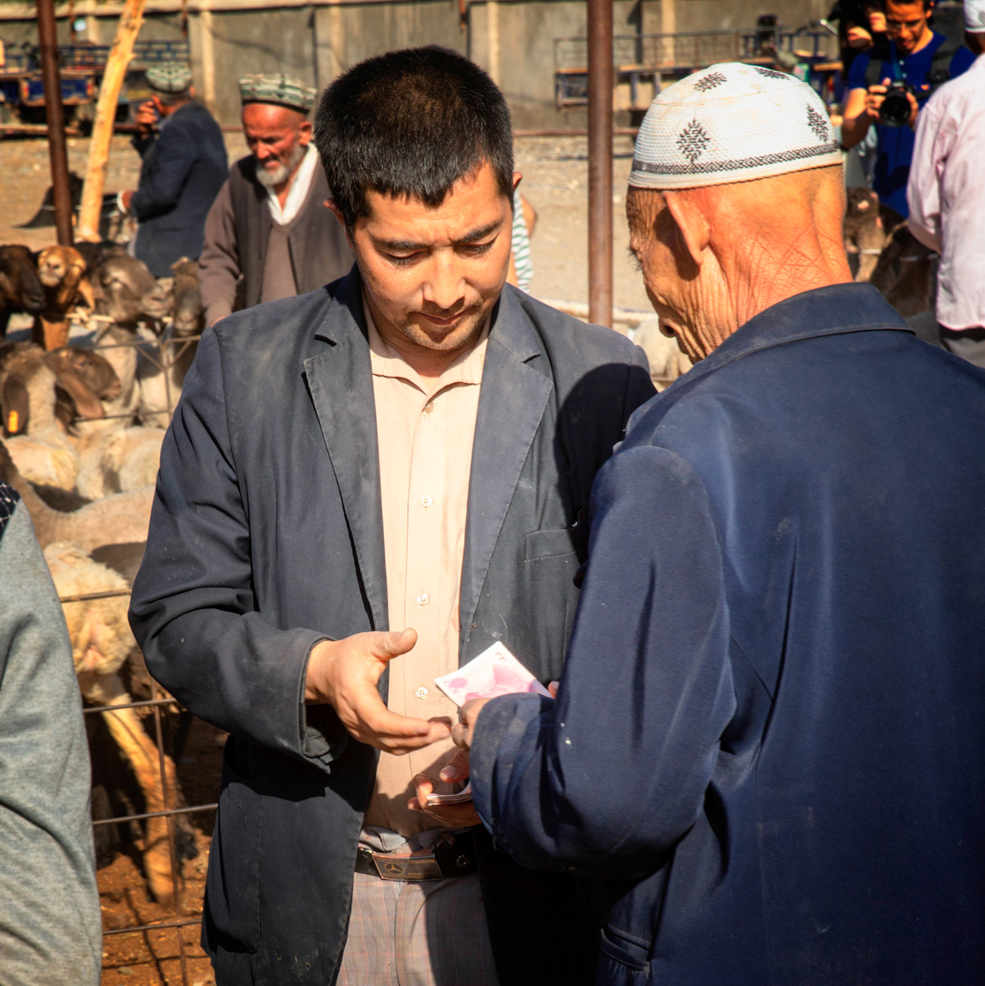 Kashgar,  China - September 9th, 2018 : Men exchanging money after agreeing the price for cattle