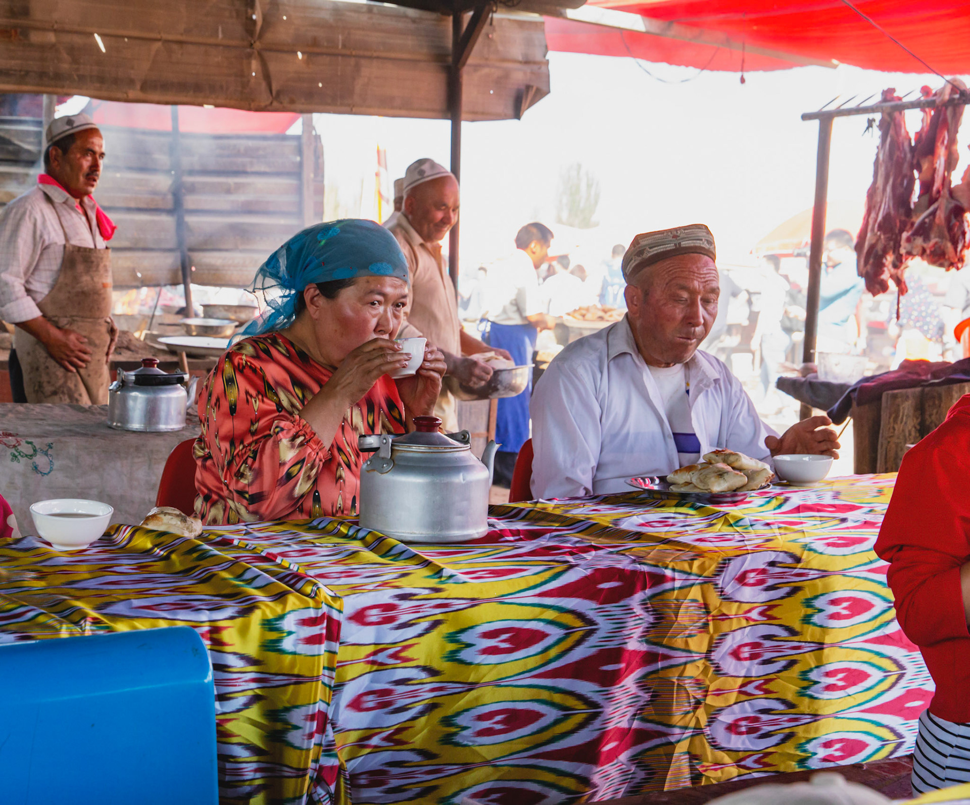 Kashgar,  China - September 9th, 2018 :Woman and man having lunch at a small food stall