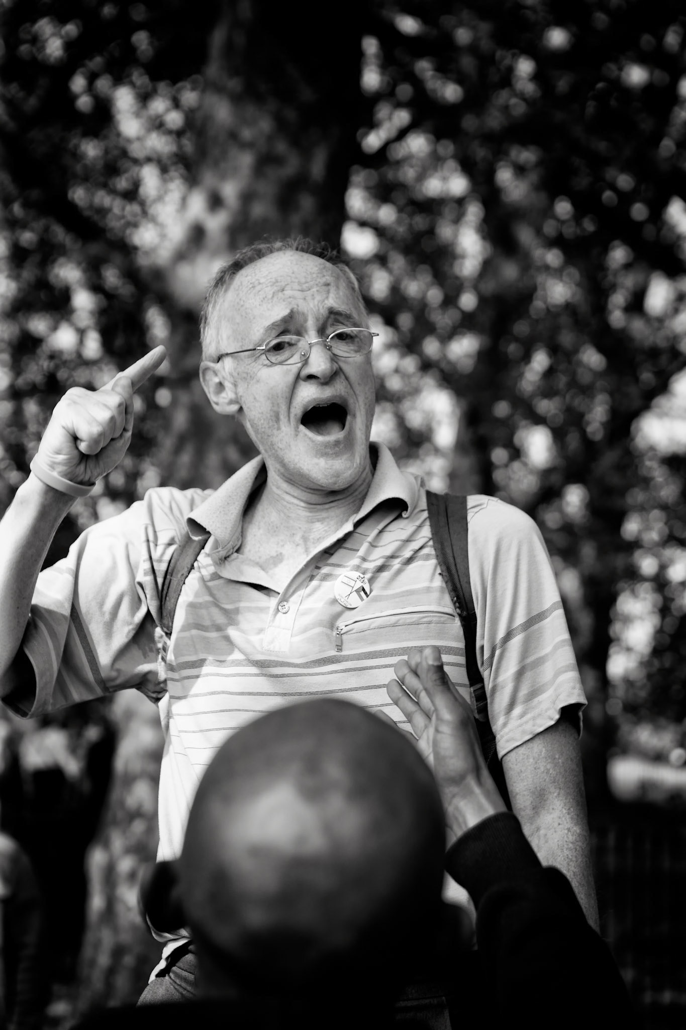 London, United kingdom - May 1, 2011 :  Hyde Park, Speaker's corner, man holding a speech on the subject of faith, is arguing vehemently with a member of his audience. Speaker's corner has been a free speech area where open-air public speaking and debate is encouraged. Although public speaking is actually allowed everywhere in the UK, the speaker's corner is traditionally the place where, as long as lawful, the most controversial issues can be aired.