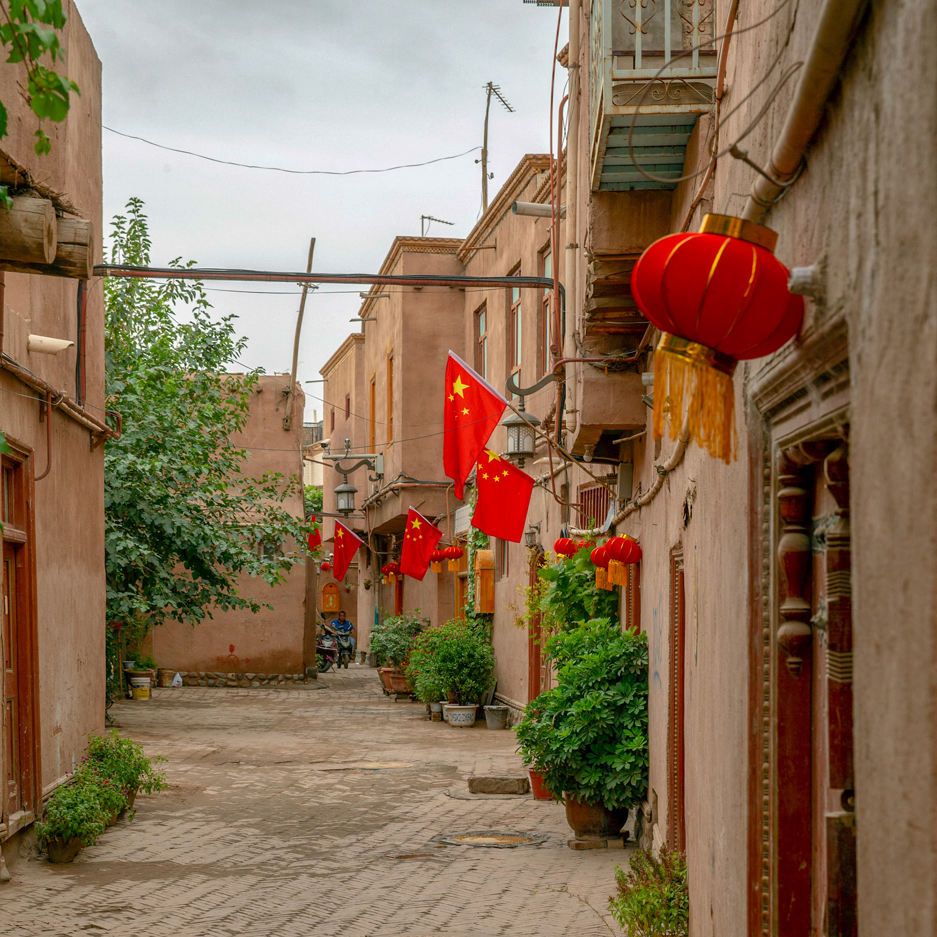 Kashgar, Xinjiang, China - September 5, 2018: View into a newly rebuilt 'old city' street. Chinese flags are ominous in the streets of Kashgar