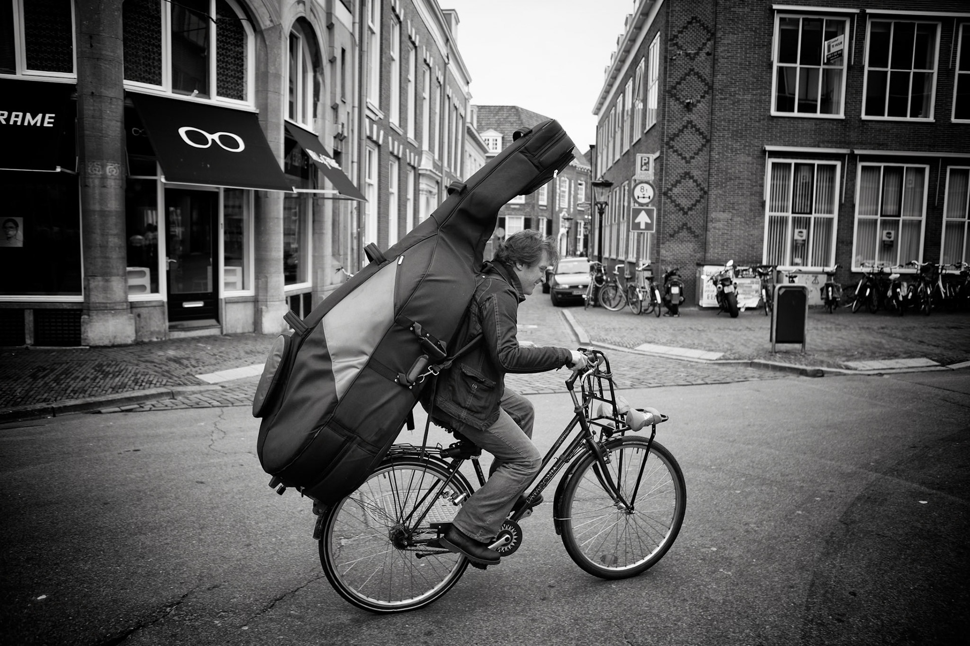 Johan Smit, 48 years old, Cello player, on his way to support Mace in a small concert. On his bike, as a good dutch cello player.