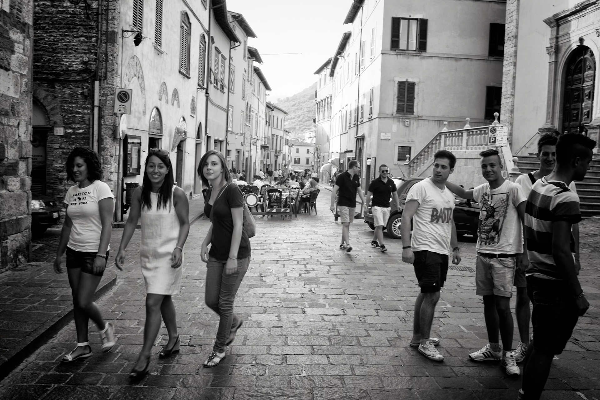 Gubbio, Italy - at 18:00 sharp the road gets blocked for traffic, Ice salon 'la Meridiana' puts tables and chairs on the road, youth hangs out and buys icecream, and Italian young men, spend their early evenings watching young women, who pretend not to notice them. puts tables and chairs on the road, youth hangs out and buys icecream, and Italian young men, spend their early evenings watching young women, who pretend not to notice them.