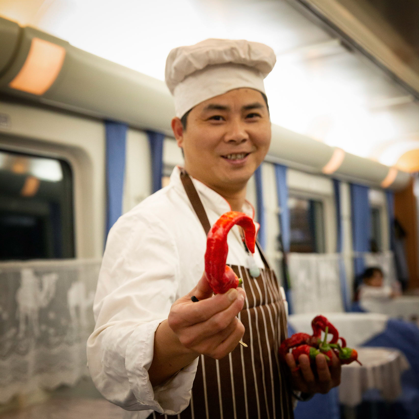 Urumqi, China - september 4, 2018 : Cook holding pepper in the restaurant carriage of the Urumqi - Kashgar train
