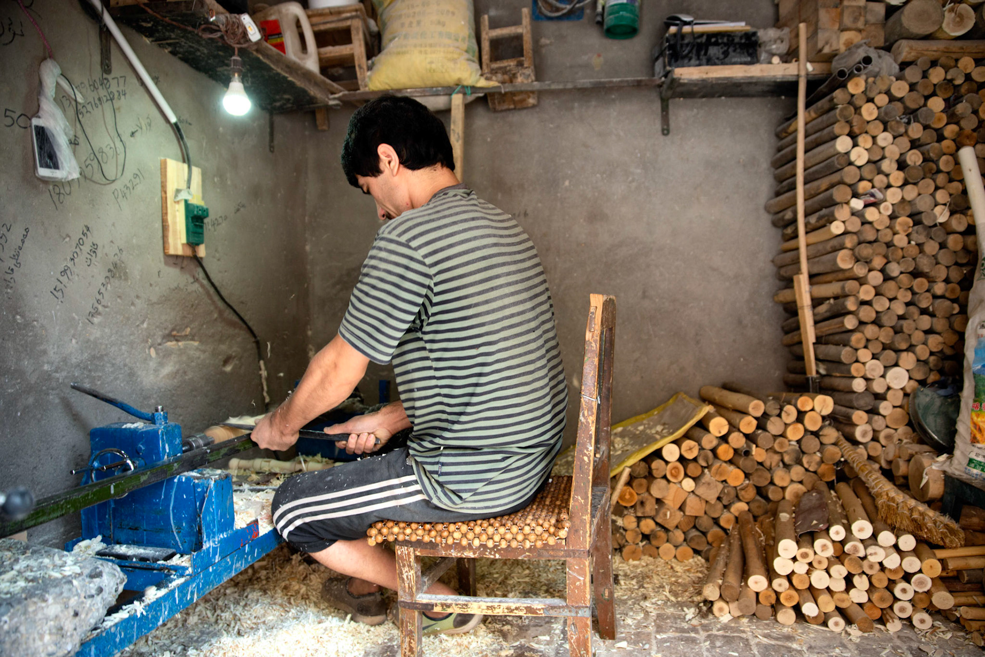 kashgar, Xinjiang, China - September 5, 2018: Man in a wood workshop, making bakery instruments.