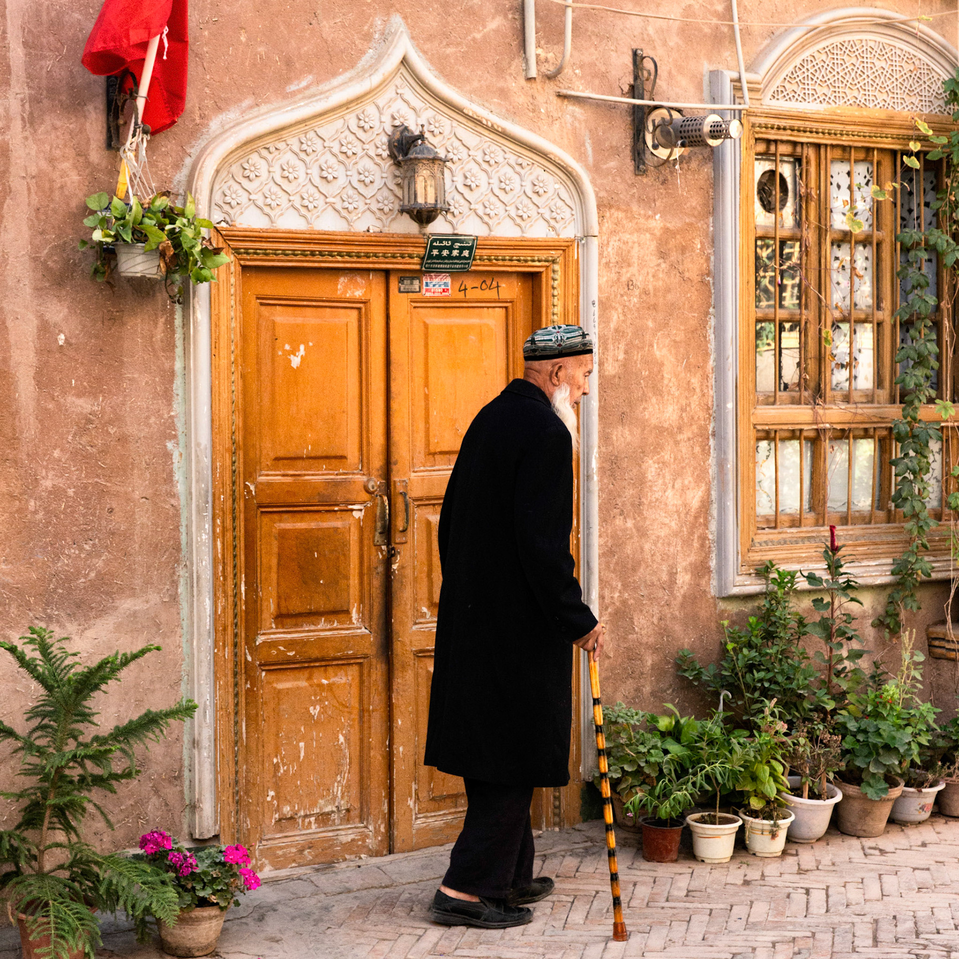 Kashgar,  China - September 11th, 2018 : Uyghur muslim man walking with a cane in the old city of Kashgar