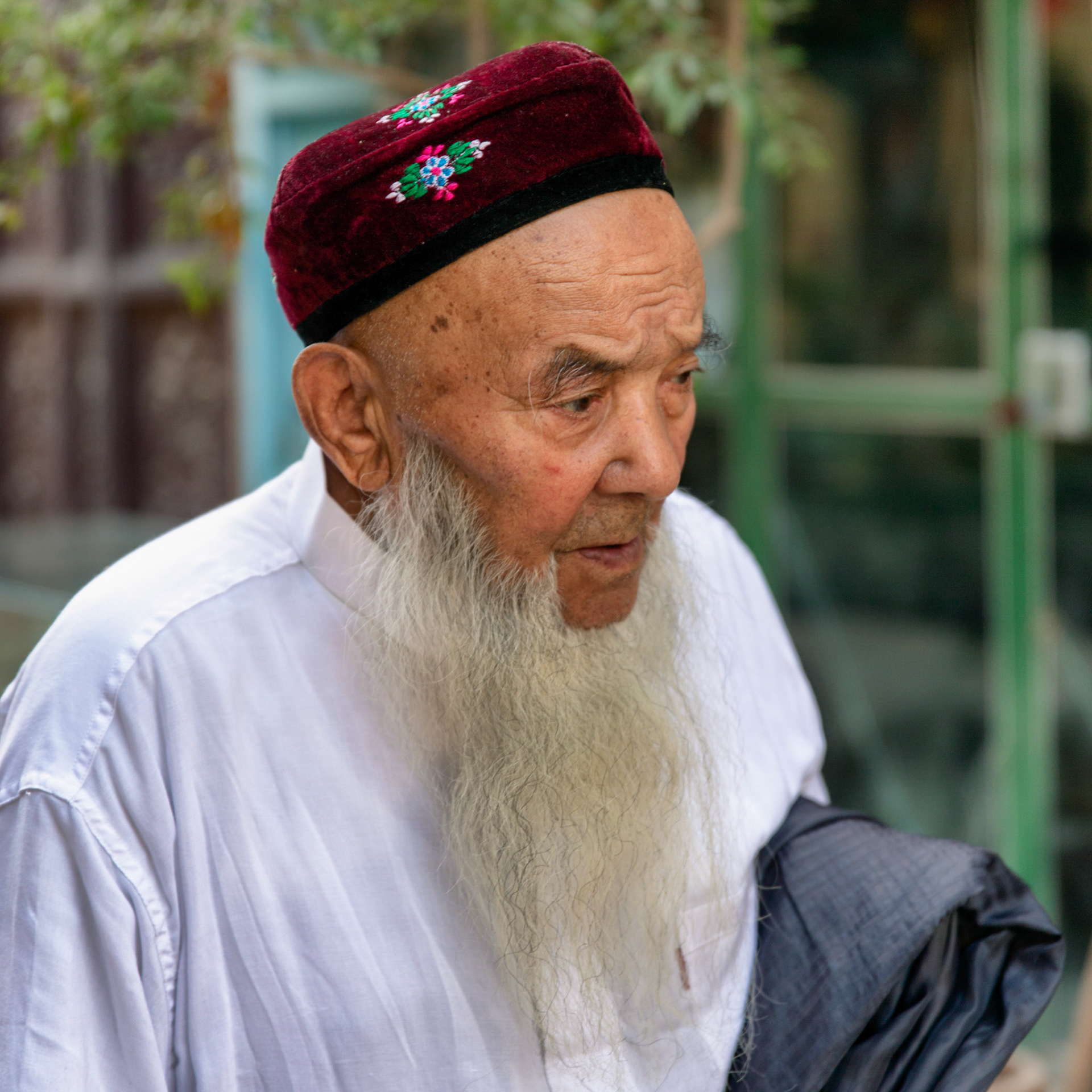 Kashgar,  China - September 8th, 2018 : Uyghur senior man, with a white beard and traditional uyghur hat.