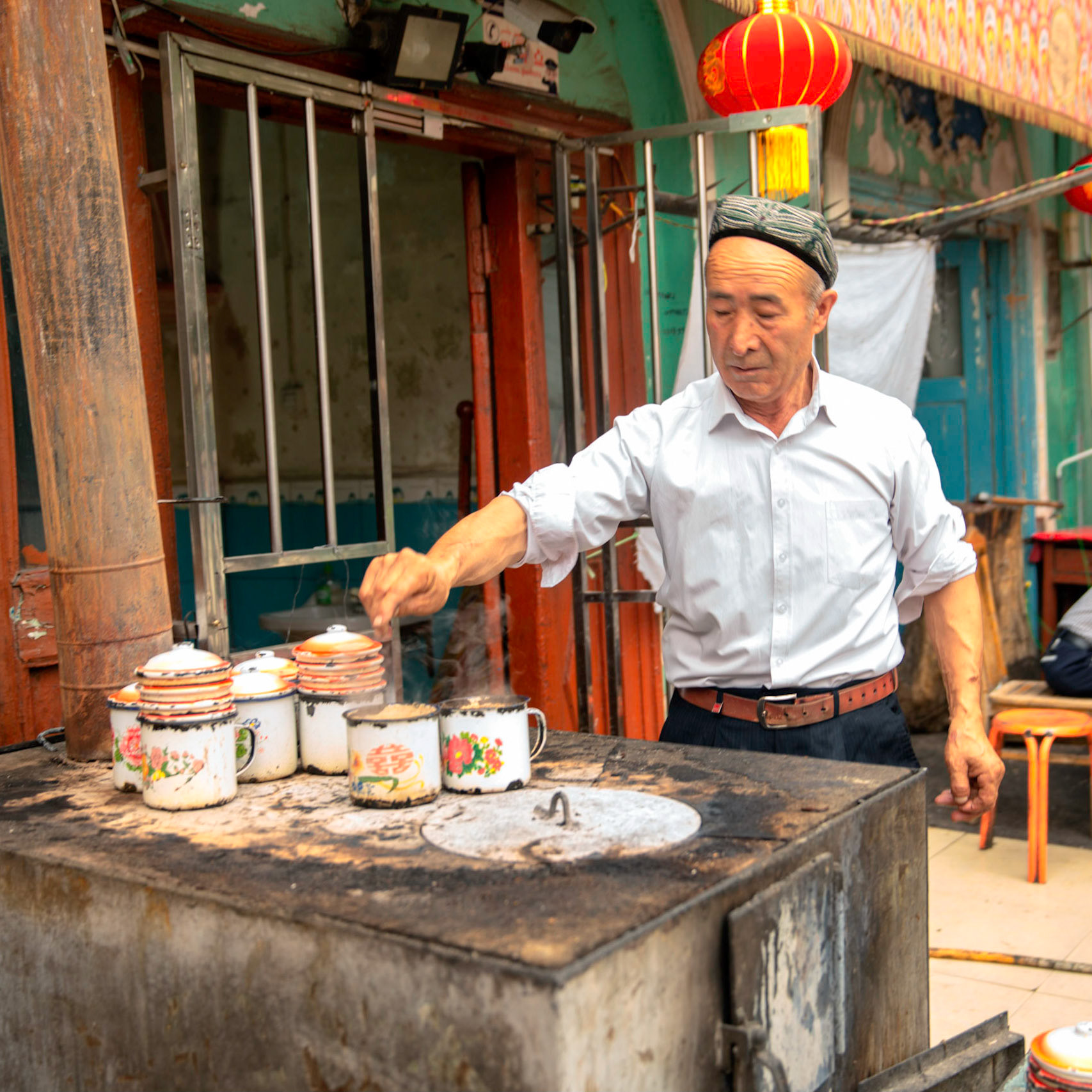 Kashgar, Xinjiang, China - September 5, 2018: Man making cups of lamb soup to be eaten with nan bread.