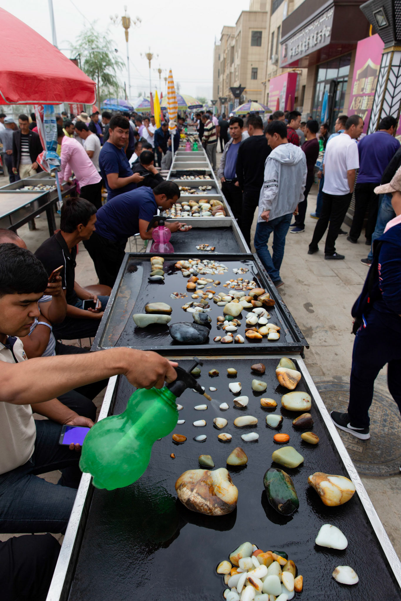 Hotan, China - September 13th 2018 :  Hotan is traditionally a place where Jade is found and sold, many locals still look for interesting stones in the river and sell them here at the Hotan Jade market. Seller keep the stones wet to make them more attractive.