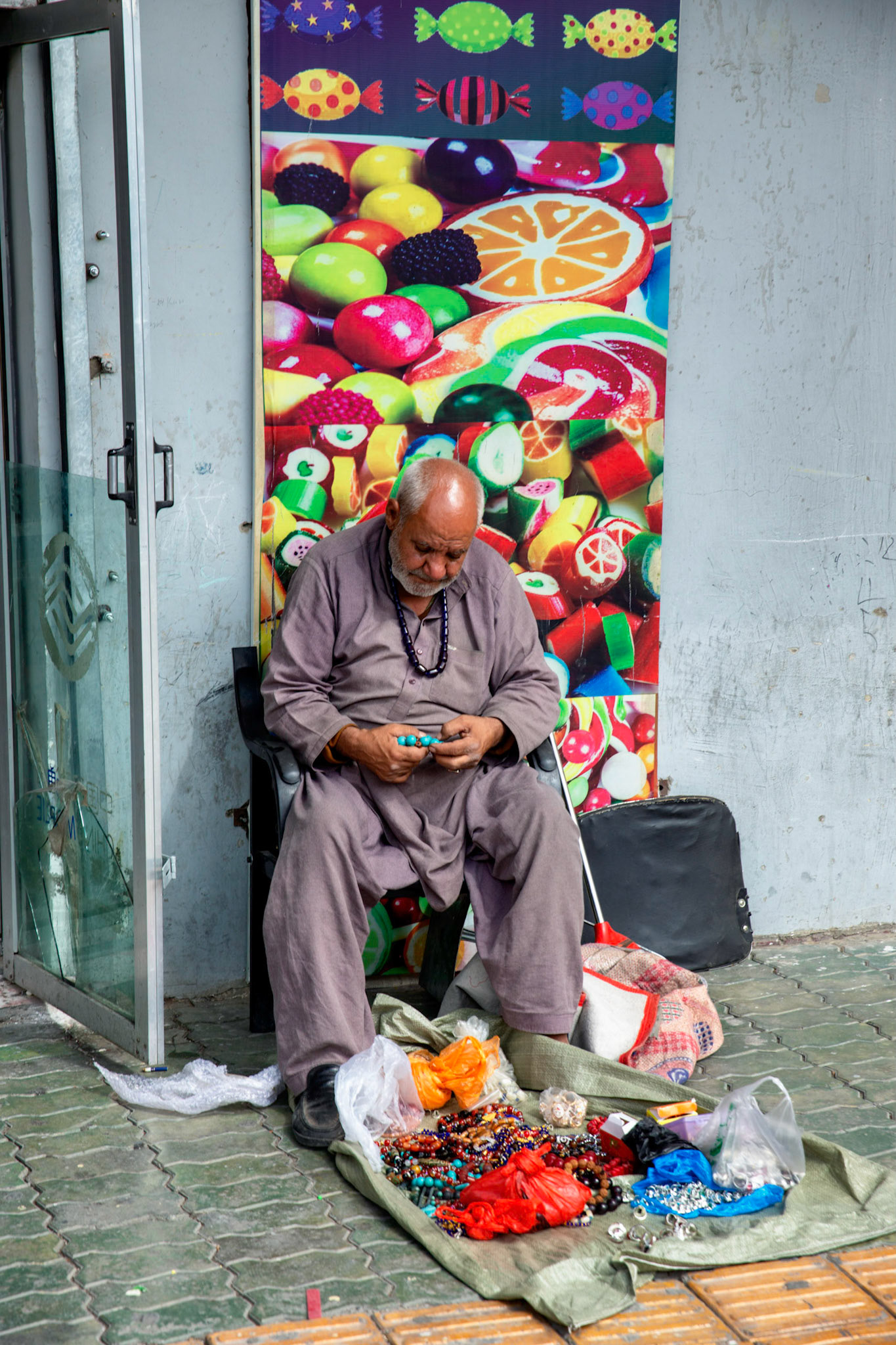 Tashgurkan, China - September 7th, 2018 : Man selling beads and jewelry on the street in Tashgurkan