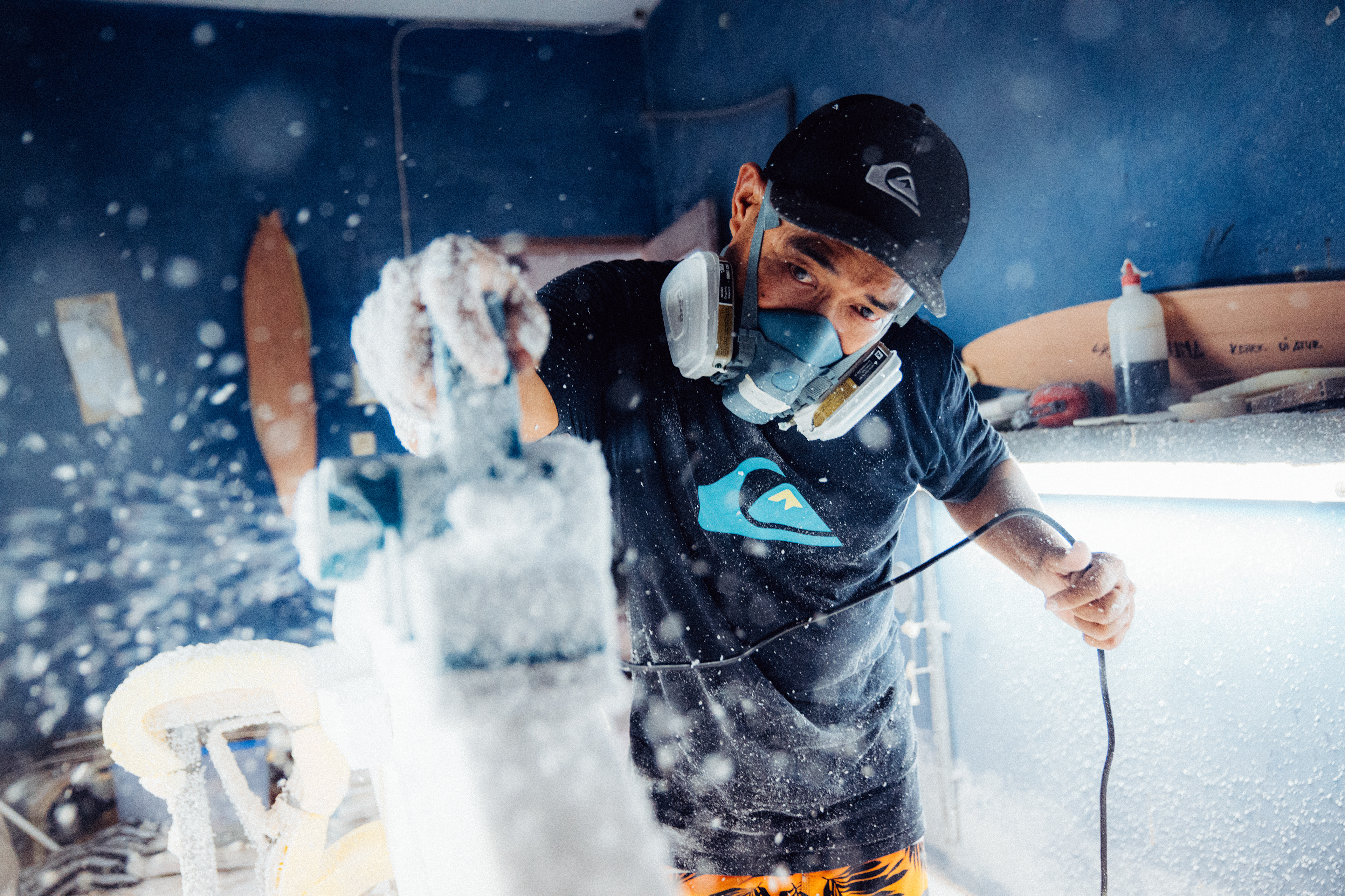 Detailaufnahme eines Shapers, der die perfekte Form eines Surfboards aus Schaumstoff modelliert.