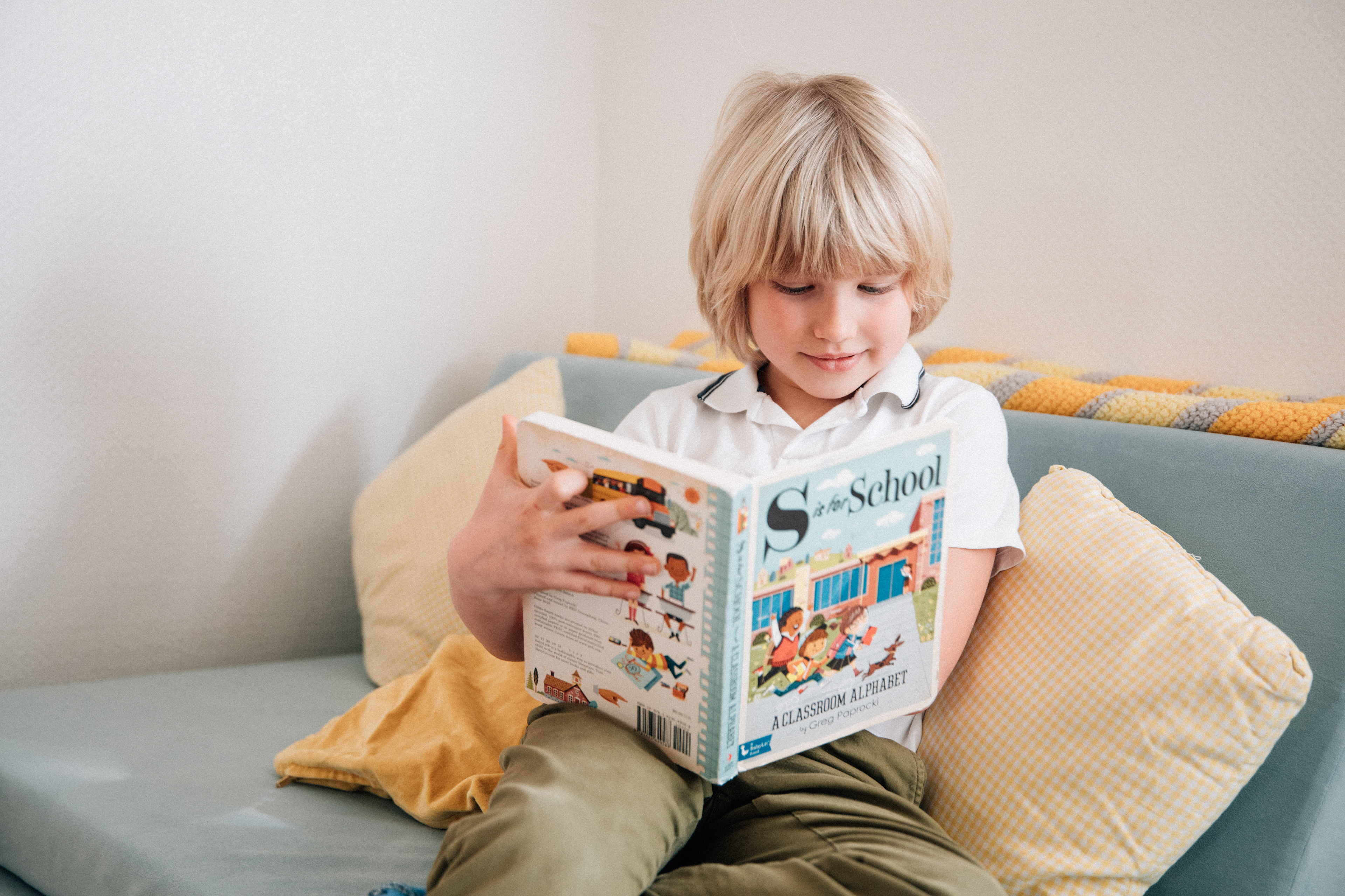 Ein Kind vertieft sich in ein buntes Bilderbuch in der Kindervilla Stuttgart.