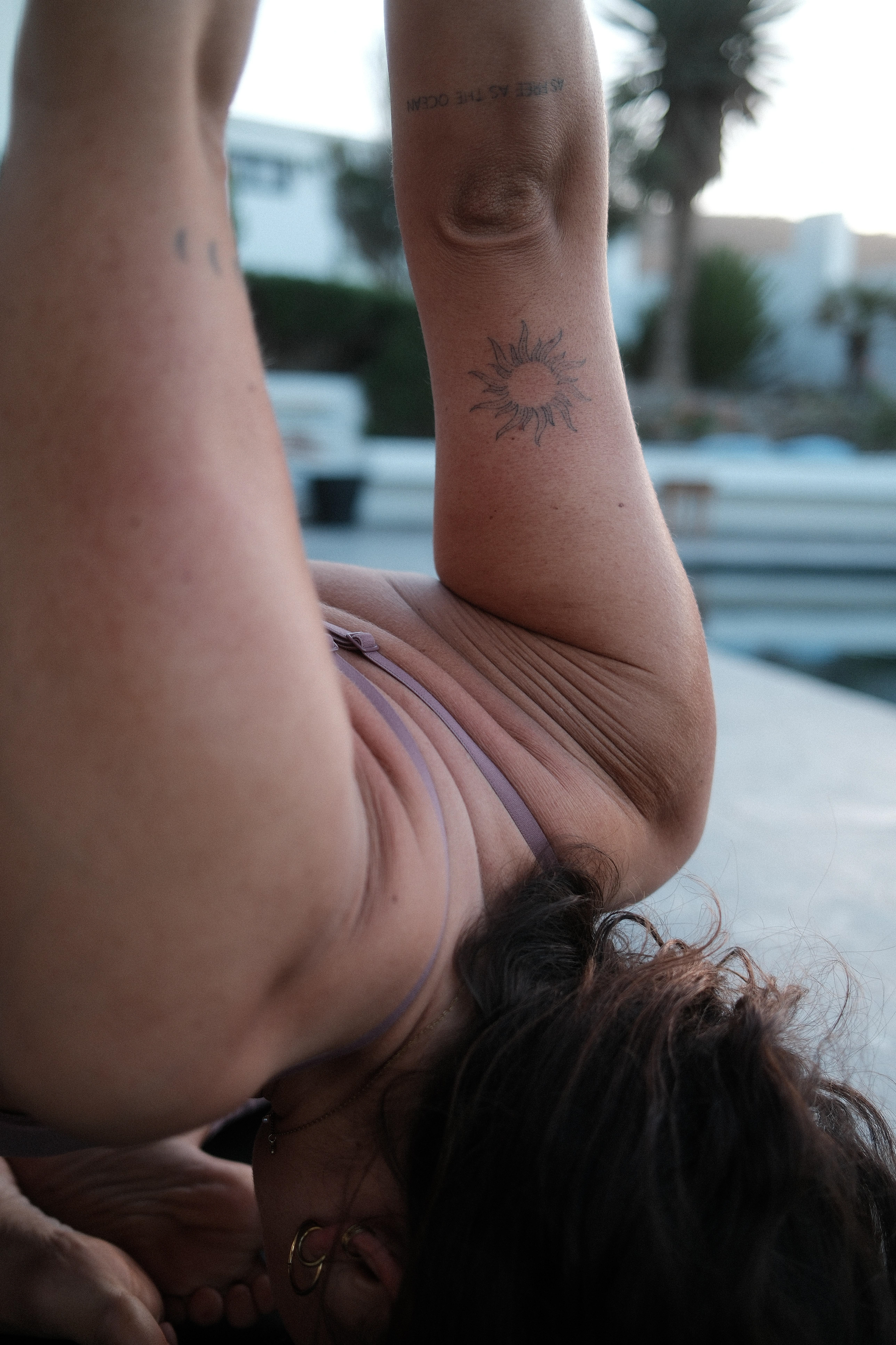 Yoga-Praktizierende mit kunstvollem Tattoo, die innere Ruhe und Körperbewusstsein verbindet.