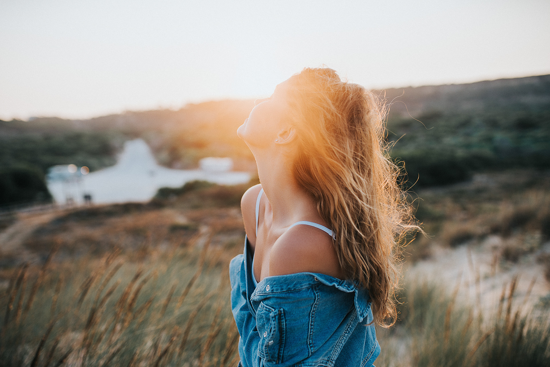 Sanfte Wellen treffen auf den Sand, während Model Helena im Gegenlicht posiert.