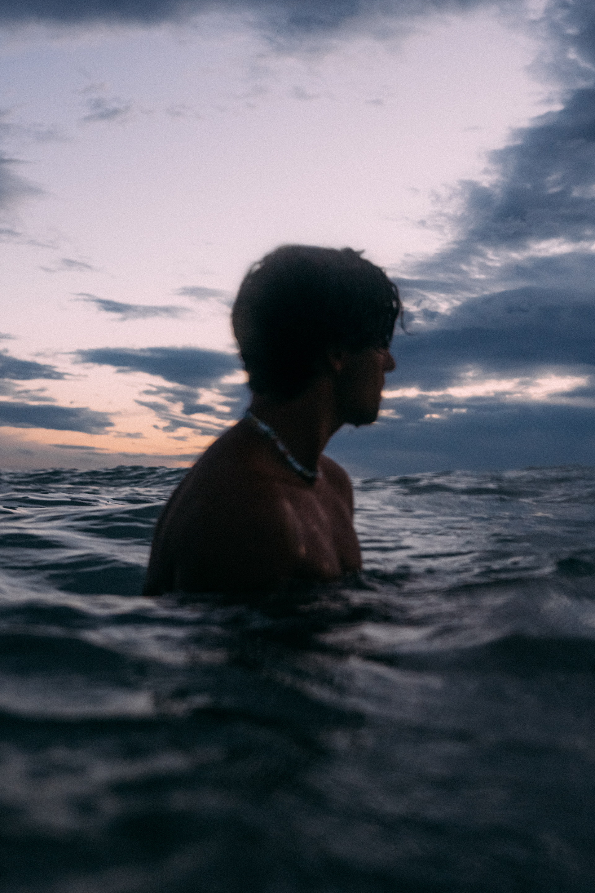 Surfer am Strand mit Board unter dem Arm – Vorfreude auf die perfekte Welle.