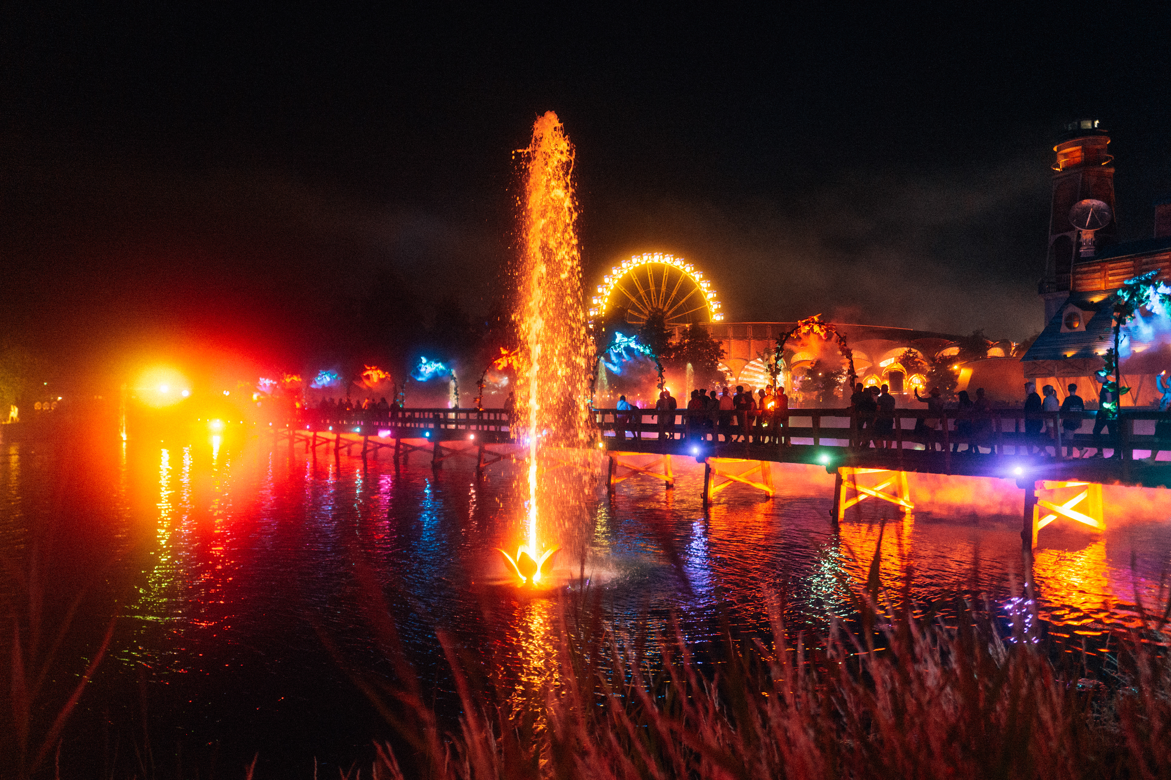 Tomorrowland See mit Lichtspiegelung – ruhiges Wasser reflektiert die bunten Farben des Festivals.